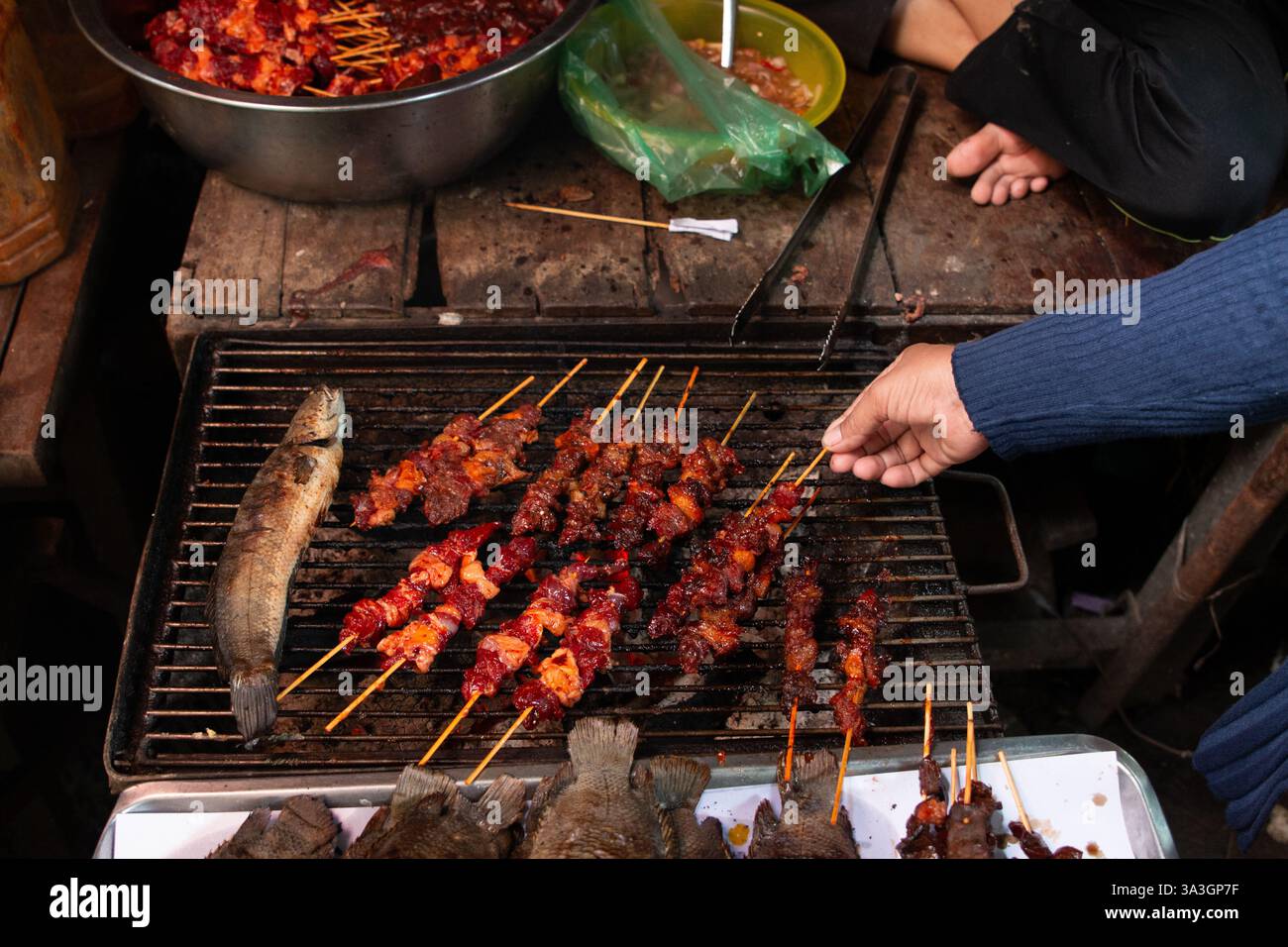 Pesce e carne alla griglia in un mercato locale di Phnom Penh, Cambogia Foto Stock