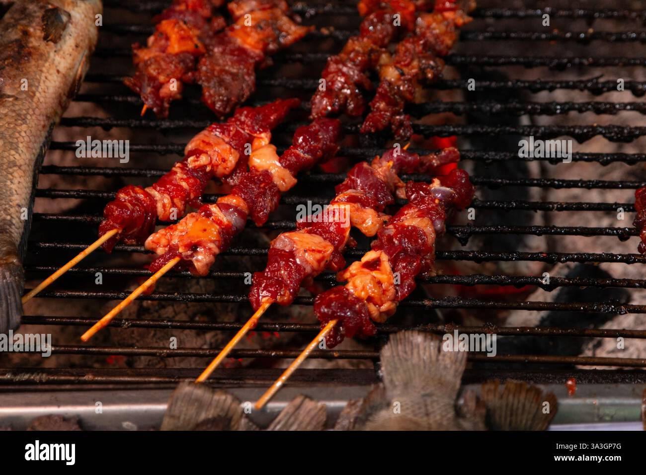 Pesce e carne alla griglia in un mercato locale di Phnom Penh, Cambogia Foto Stock