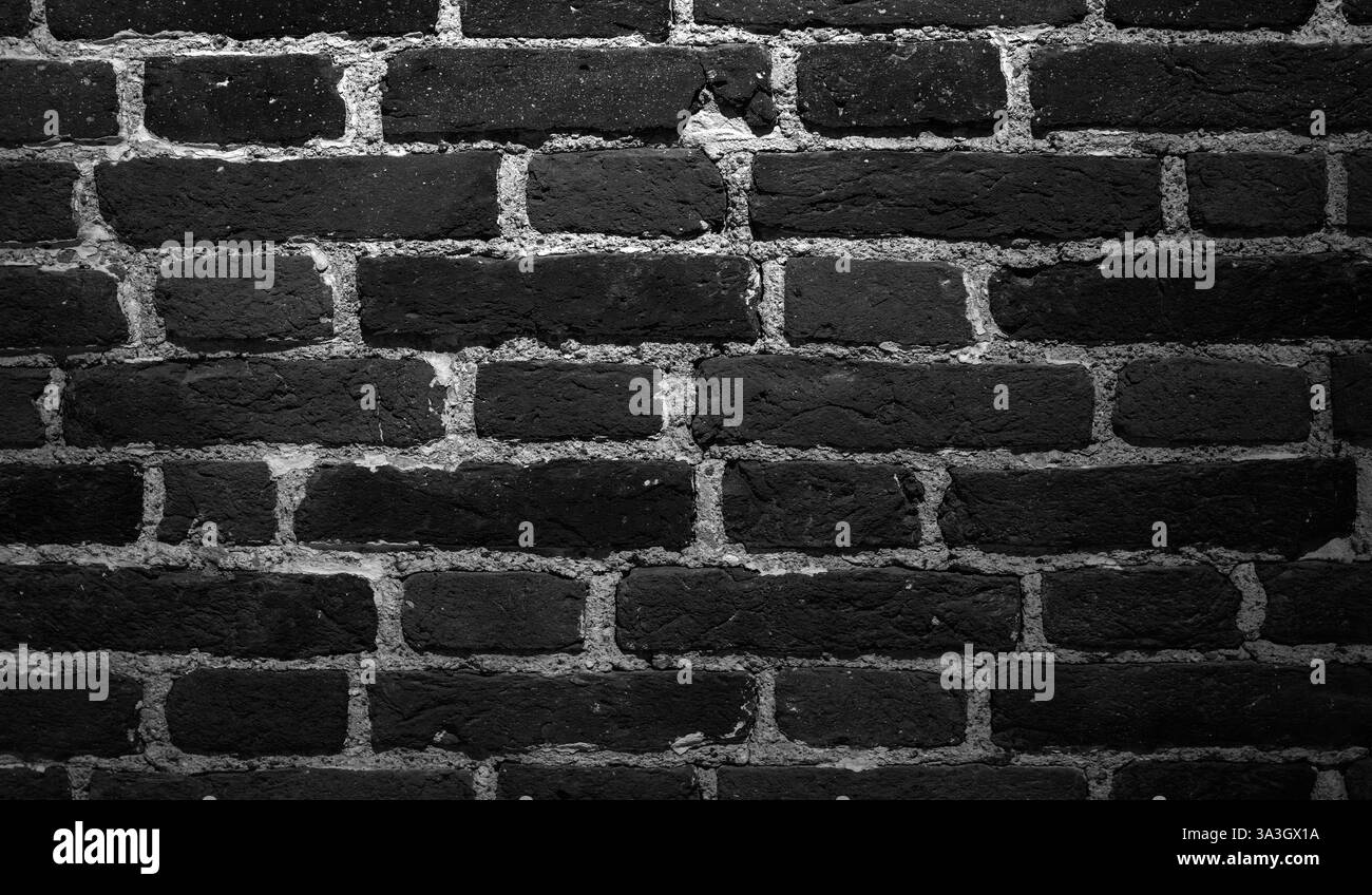 Vecchia parete in mattoni neri grunge, texture di sfondo, vista frontale, foto in bianco e nero Foto Stock