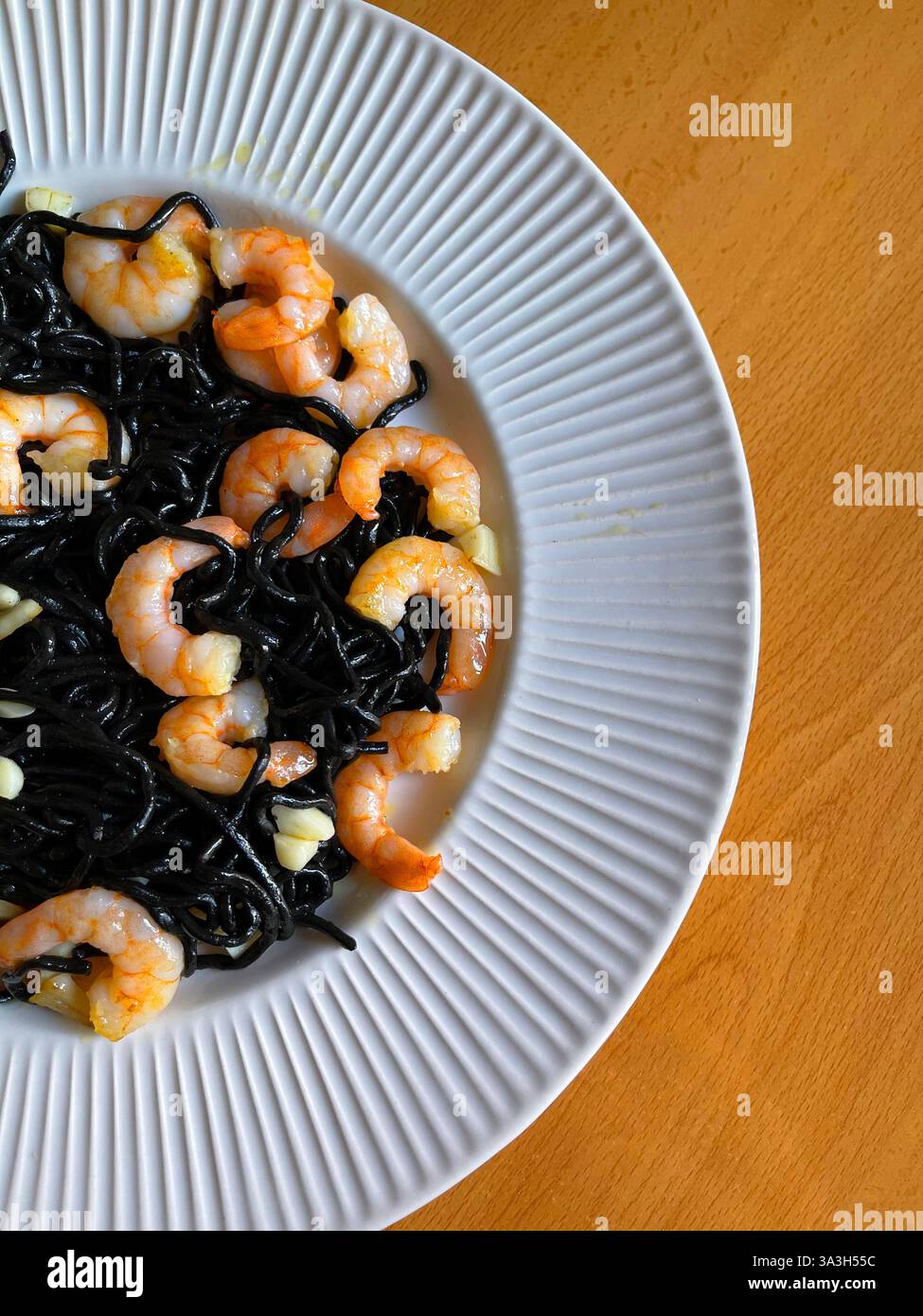 Spaghetti al nero con gamberi e aglio. - Immagine stock catturata con smartphone