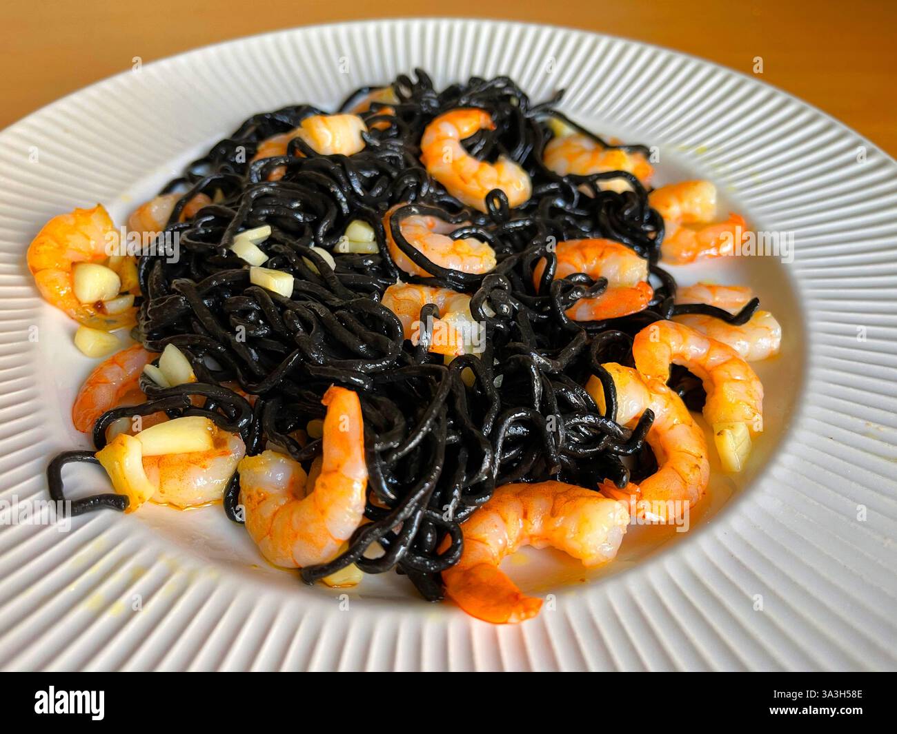 Spaghetti al nero con gamberi e aglio. - Immagine stock catturata con smartphone