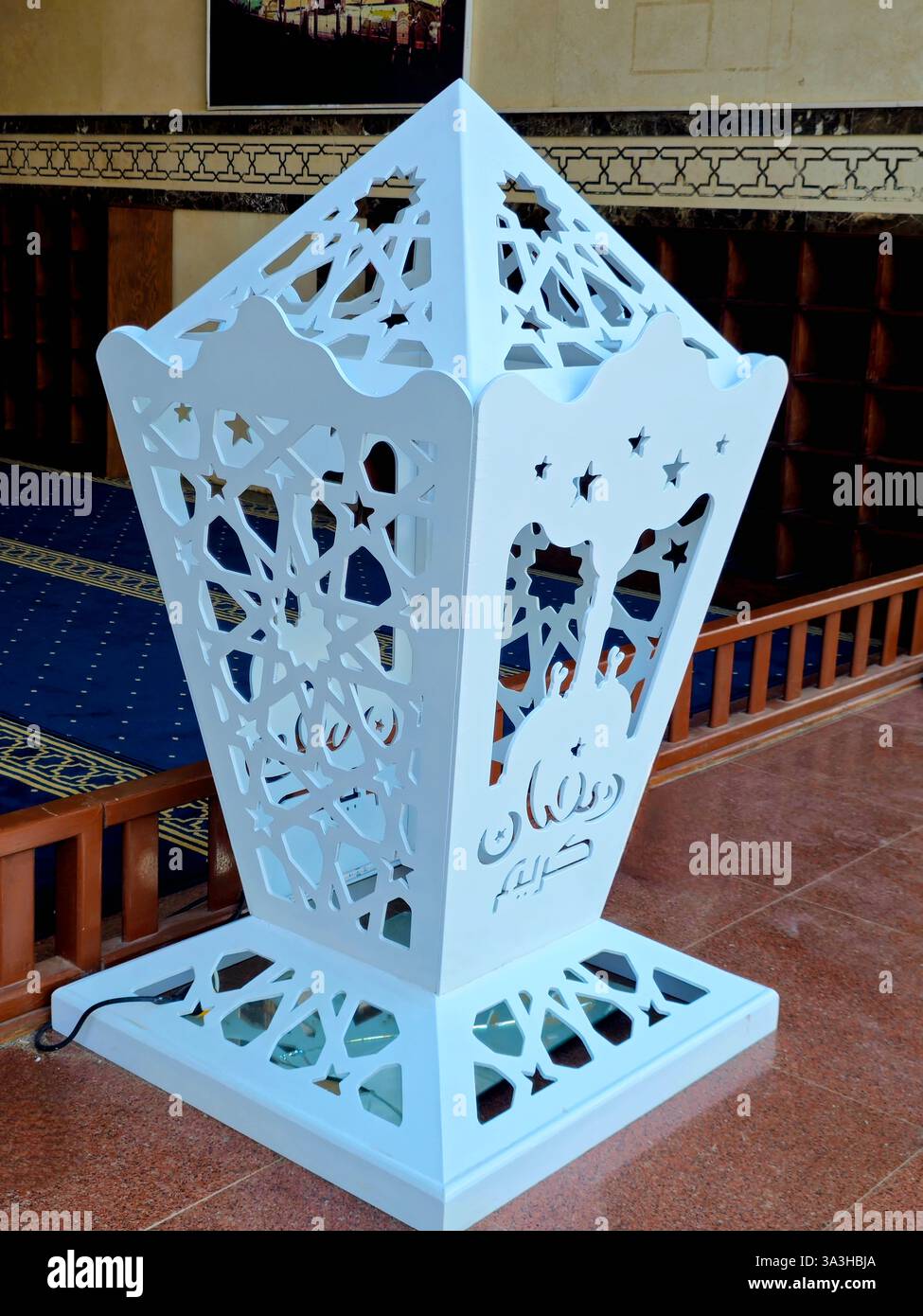 Traduzione di testo arabo (felice e generoso Ramadan Kareem), su una lampada a lanterna Ramadan fanous, una grande Lanterna all'ingresso di una grande moschea al Cairo Foto Stock