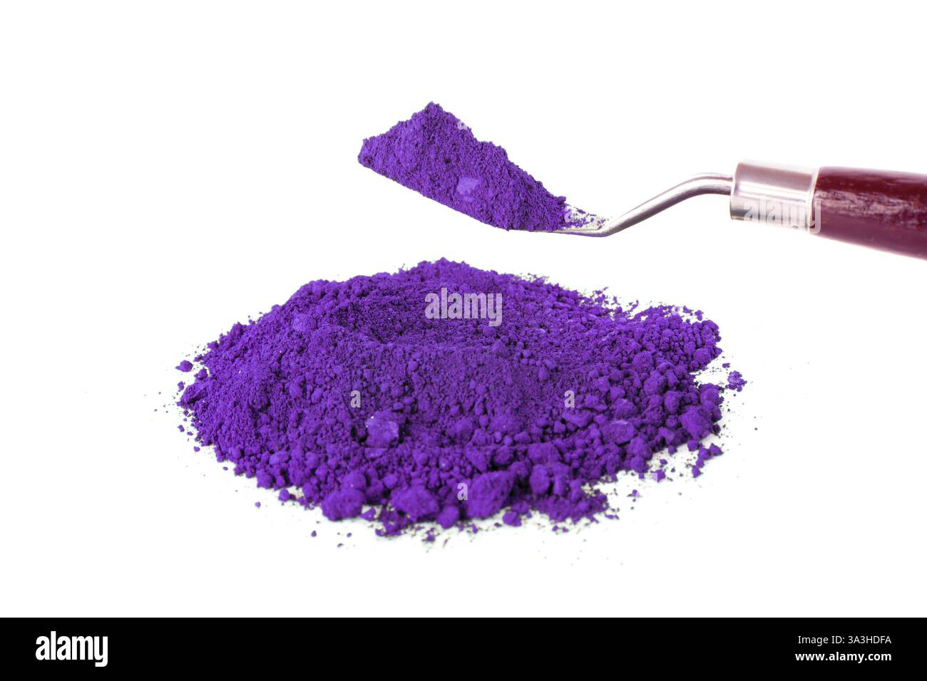 La polvere viola brillante si trova su una superficie bianca pulita, perfetta per artisti e artigiani che cercano di creare colori vivaci nei loro progetti. Foto Stock