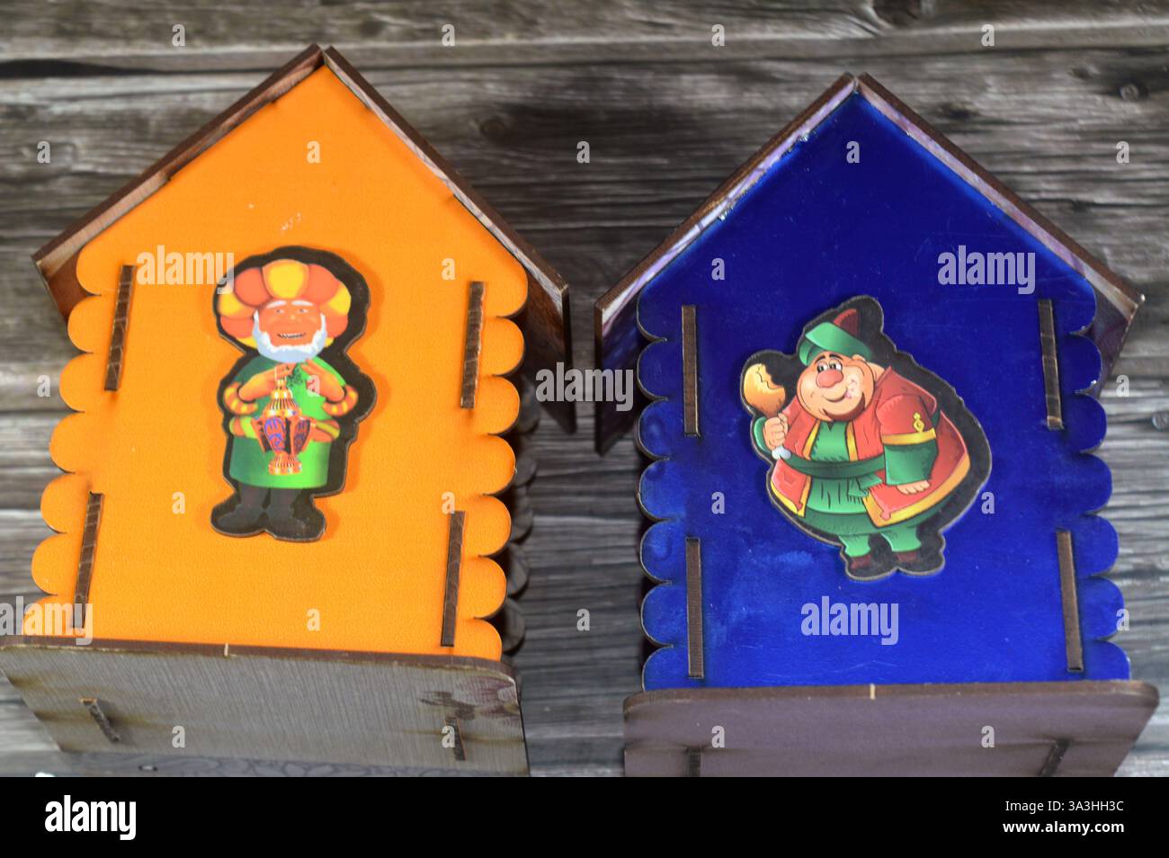 Cairo, Egitto, 22 gennaio 2025: Scatola dei soldi, banca dei penny in legno con illustrazione del personaggio del mese Ramadan con lampada Fanous lanterna Ramadan, tradi Foto Stock