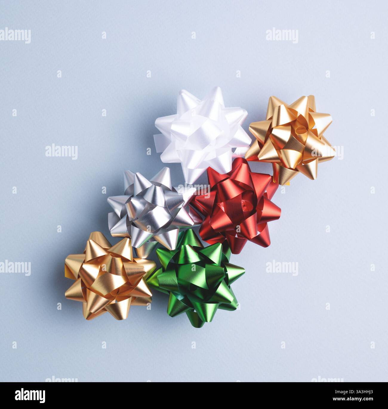 Сolorful fiocchi da regalo su sfondo grigio-blu. Set di nastri decorativi per feste per confezioni attuali, vista dall'alto. Foto Stock