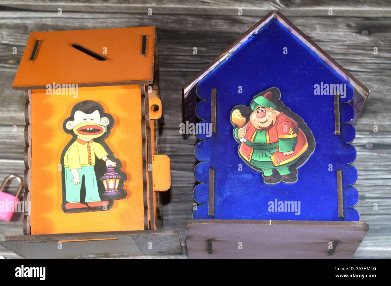 Cairo, Egitto, 22 gennaio 2025: Scatola dei soldi, banca dei penny in legno con illustrazione del personaggio del mese Ramadan con lampada Fanous lanterna Ramadan, tradi Foto Stock