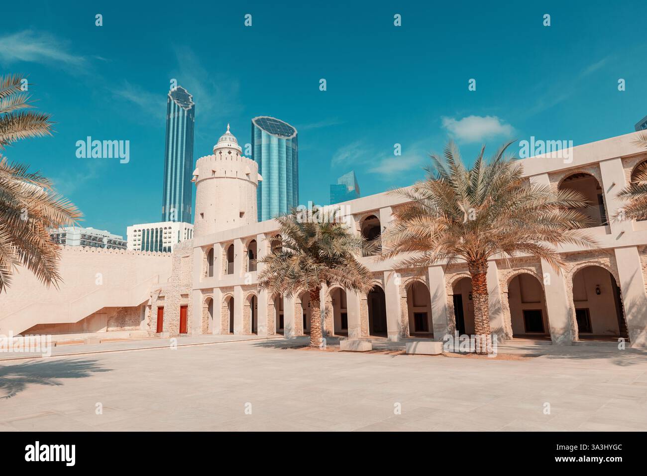16 gennaio 2025, Abu Dhabi, Emirati Arabi Uniti: Storico forte Qasr al Hosn circondato da palme ed edifici moderni Foto Stock