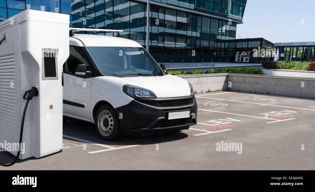 Furgone elettrico con stazione di ricarica per veicoli elettrici. Foto Stock