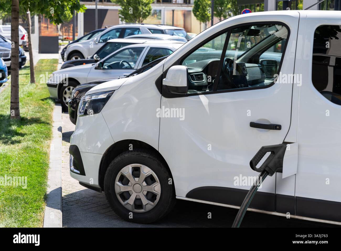 Furgone elettrico con stazione di ricarica per veicoli elettrici. Foto Stock
