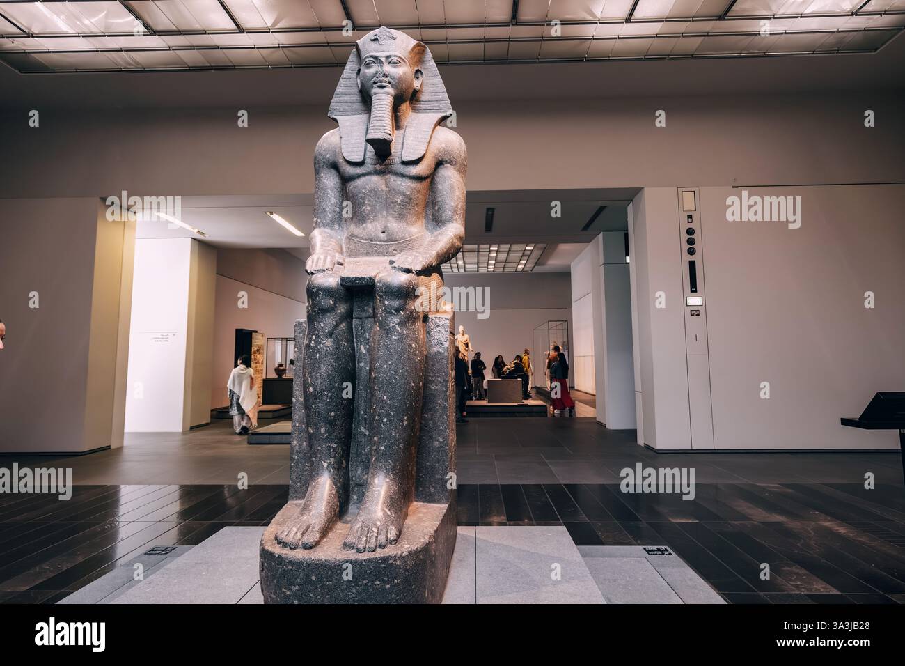 17 gennaio 2025, museo del Louvre di Abu Dhabi, Emirati Arabi Uniti: Maestosa statua di un faraone egizio, seduto e con simboli del potere Foto Stock