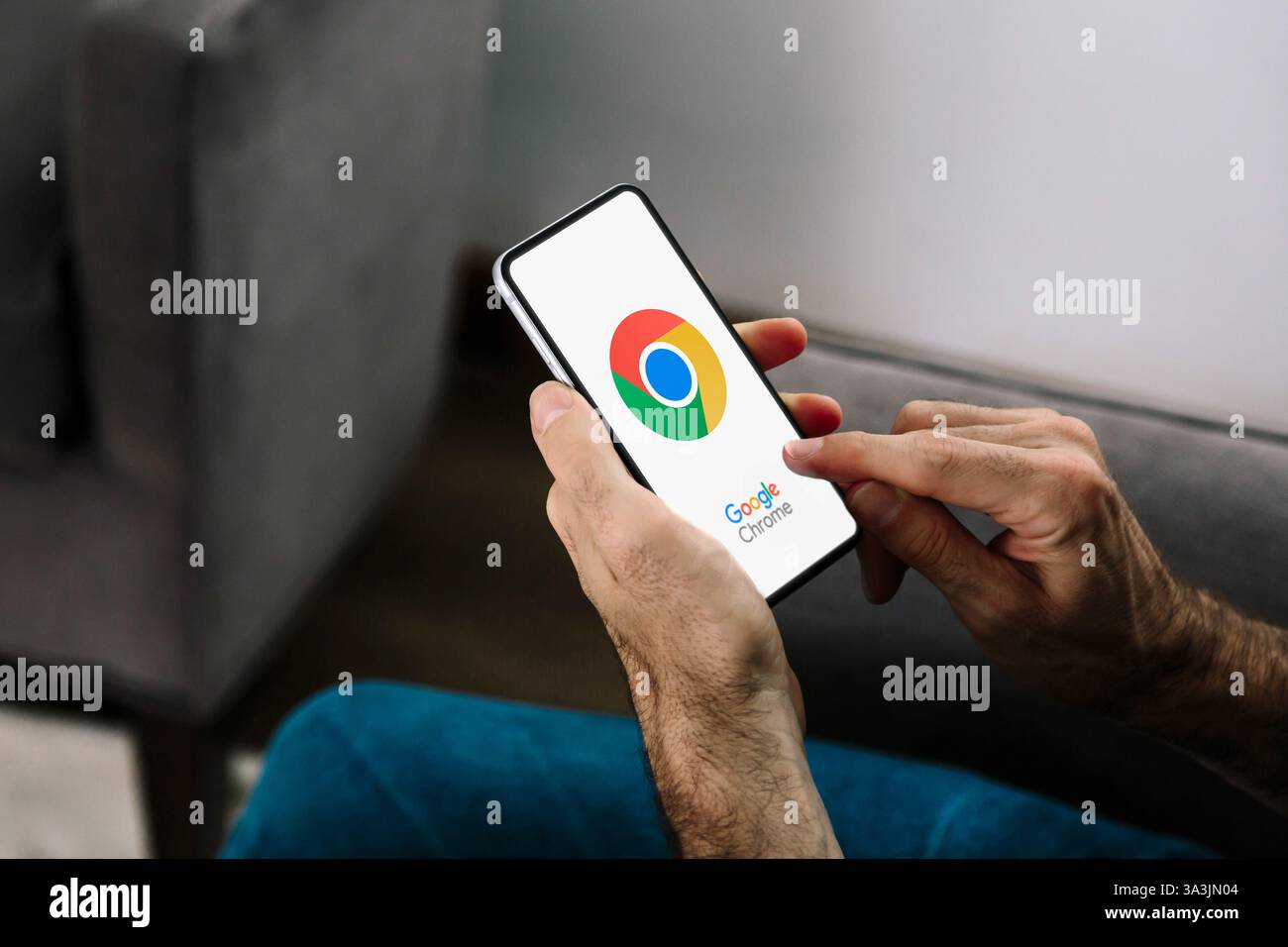 Uomo che utilizza un telefono cellulare con il browser Google Chrome sullo schermo. Rosario, Argentina - 15 marzo 2025. Foto Stock