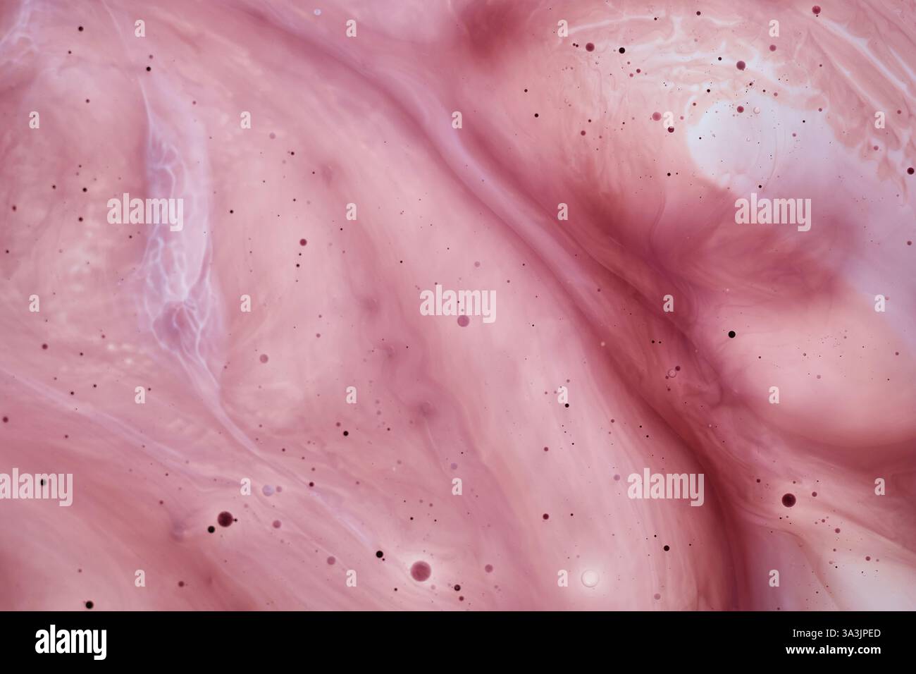 Foto macro di un liquido rosa con striature lisce e piccole bolle. Il motivo astratto ricorda il marmo o la nebulosa spaziale. Ottimo background per Foto Stock