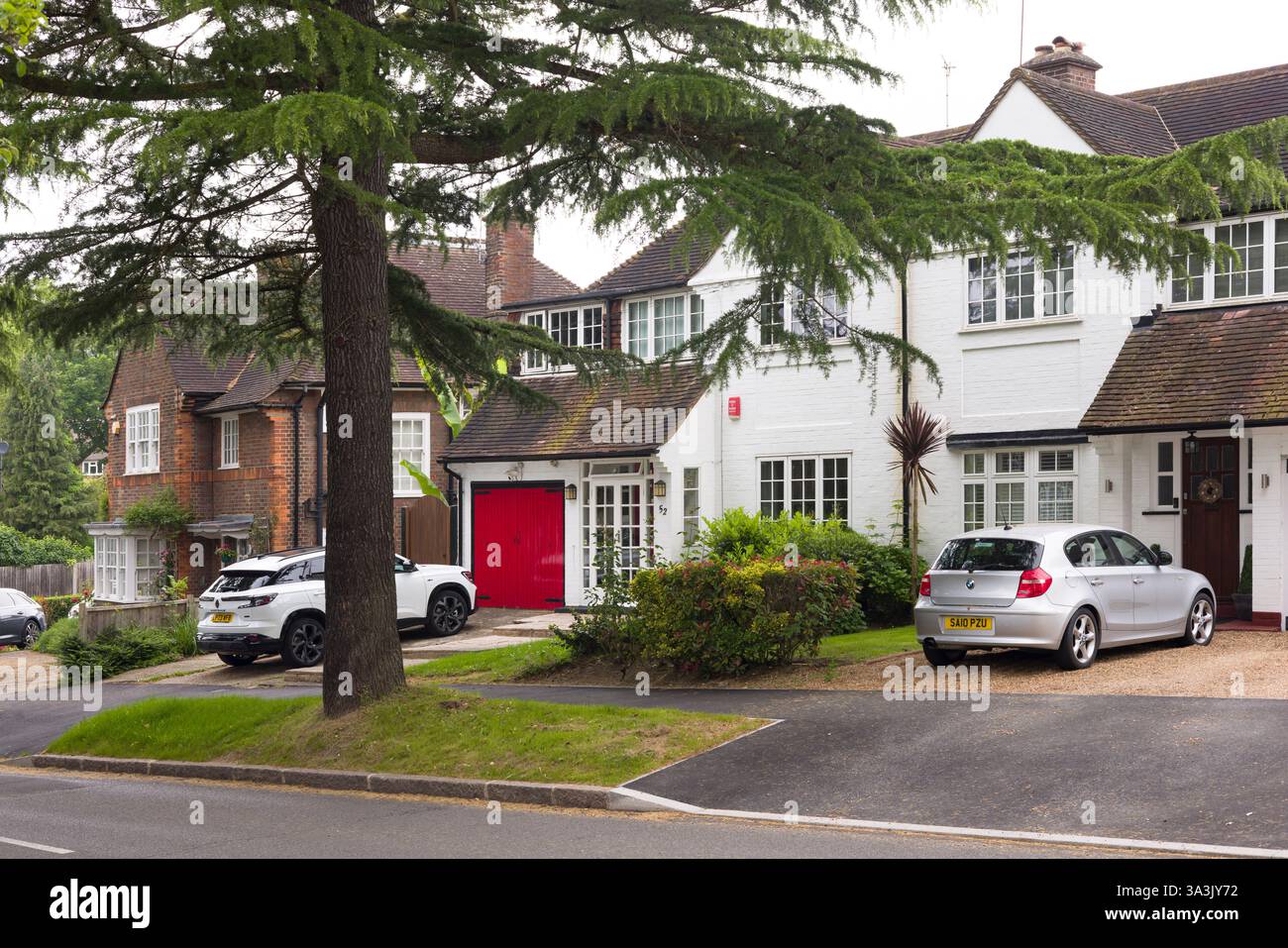 Londra, Regno Unito - 18 maggio 2024. Fila di case bifamiliari con auto parcheggiate sul vialetto in un'area protetta di un sobborgo londinese. Pinner, Londra, Regno Unito Foto Stock