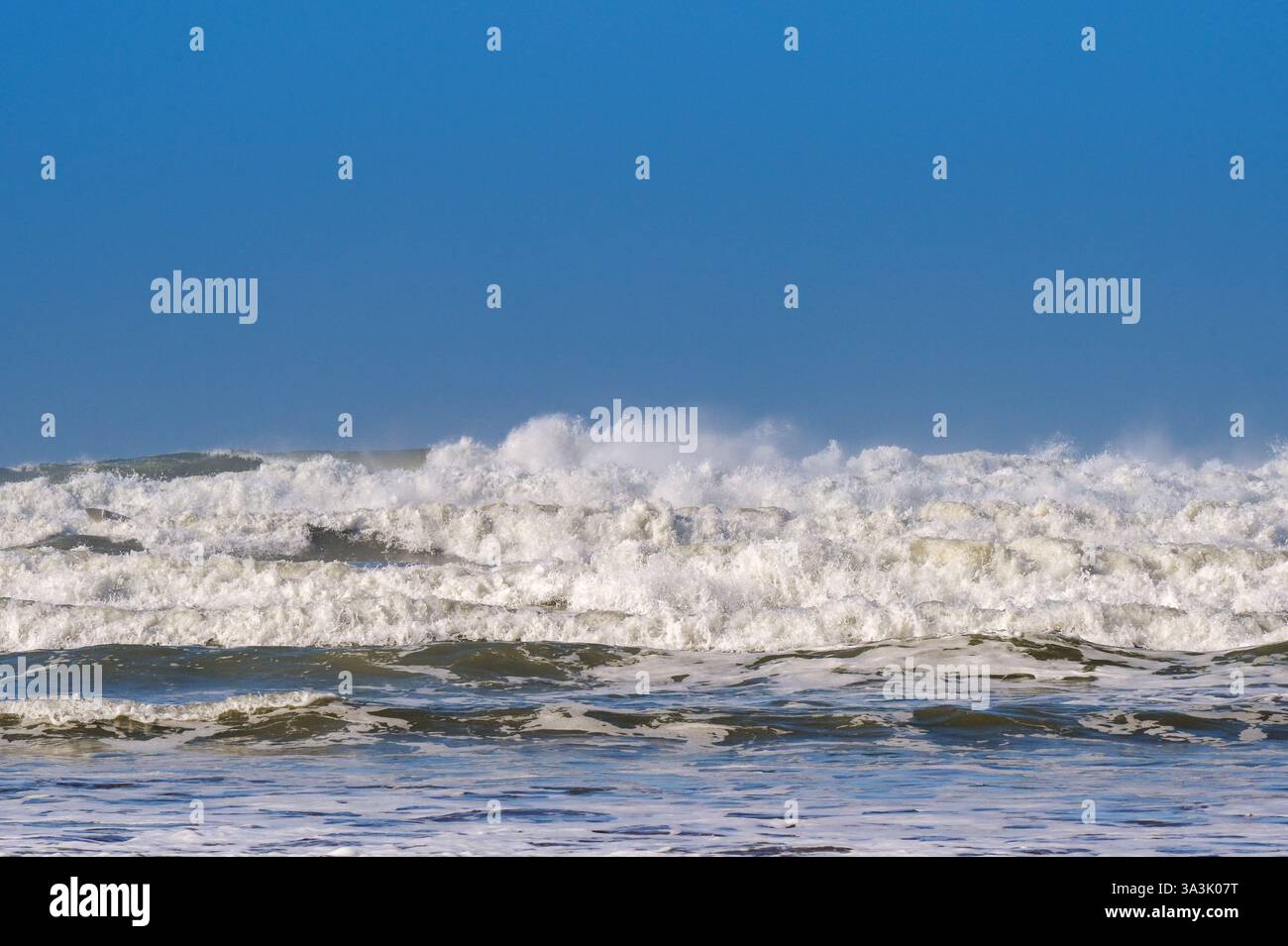 Infrangere le onde mentre la marea scorre su una spiaggia. Niente persone. Sfondi. Foto Stock