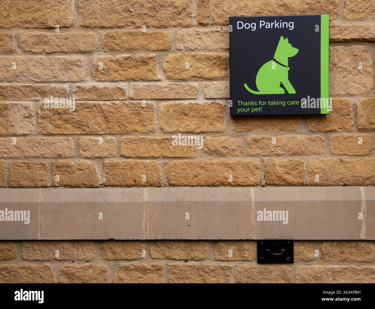 Muro in mattoni con un cartello verde per il parcheggio dei cani, con la silhouette di un cane e un messaggio di ringraziamento per la cura degli animali domestici Foto Stock