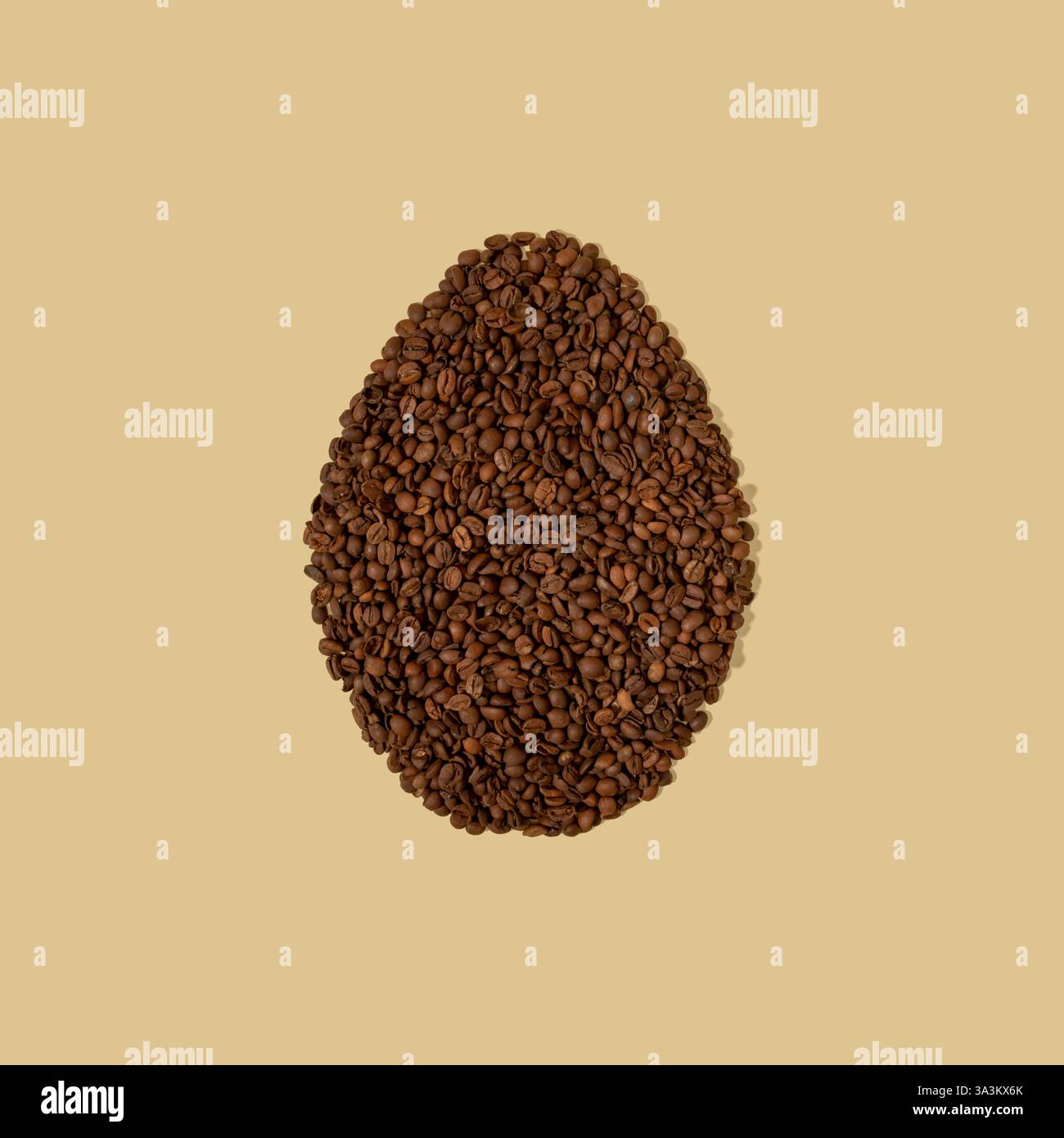Uovo di Pasqua composto da chicchi di caffè su sfondo beige chiaro con spazio per le copie. Minimalismo pasquale. Foto Stock