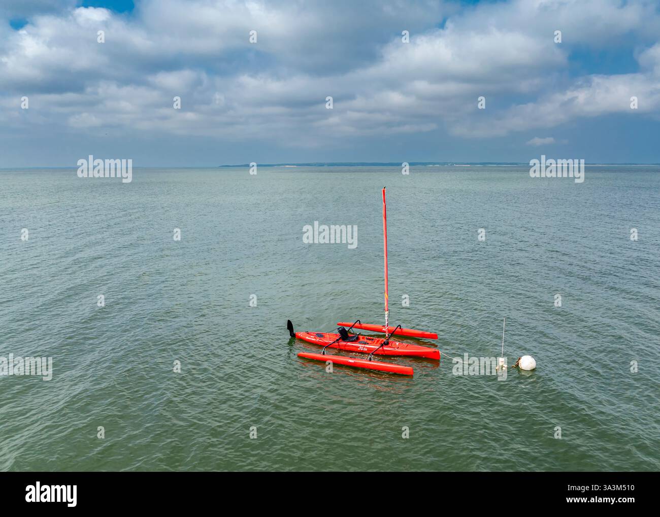 una barca a vela hobie rossa molto luminosa su un ormeggio Foto Stock