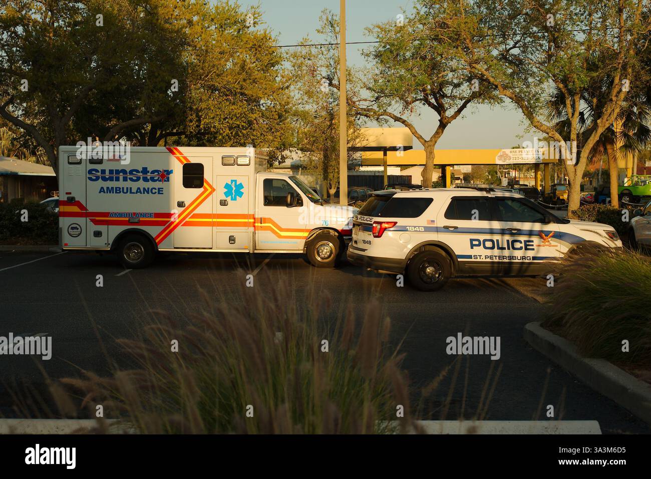 Solo per uso editoriale 15 marzo 2025. St. Petersburg, FL, USA, auto e ambulanza della polizia nel parcheggio vicino alle intersezioni 49th St N e Central Avenue af Foto Stock