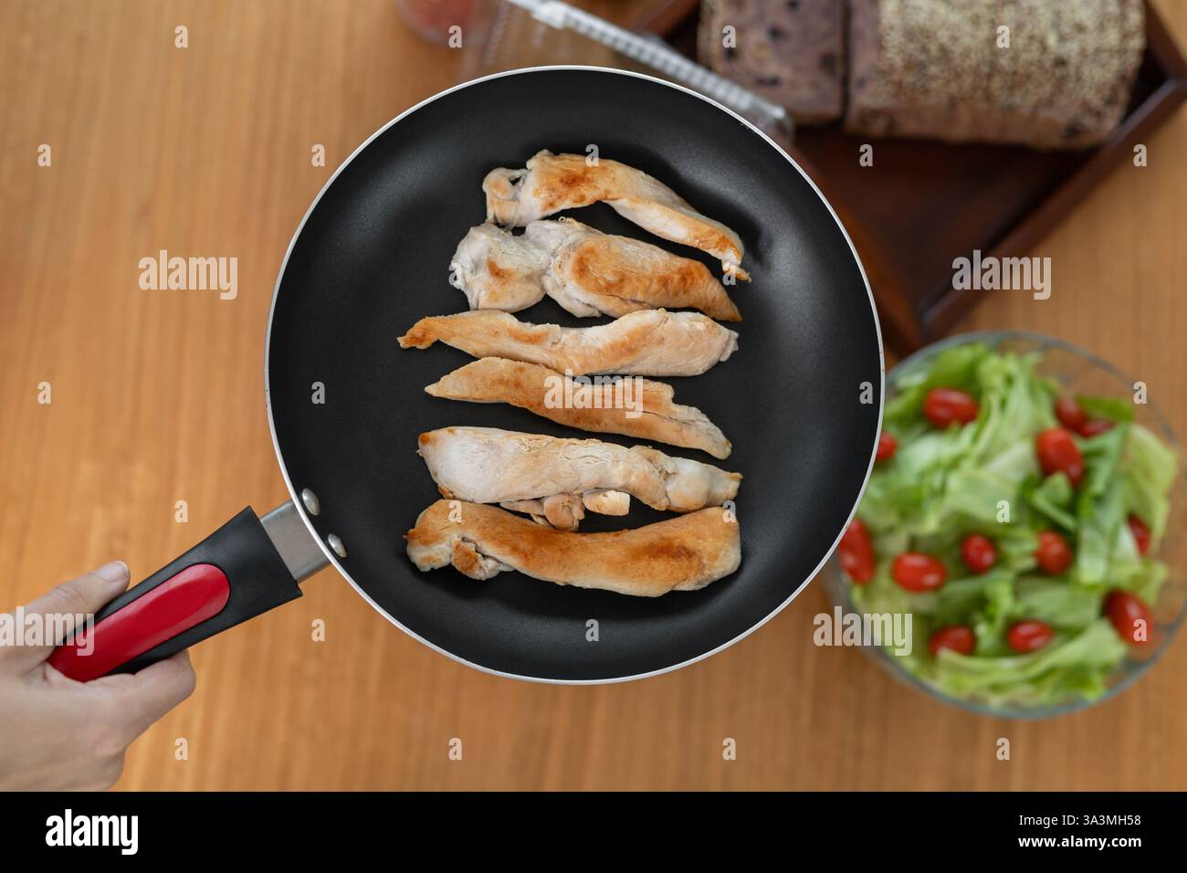 Strisce di pollo dorate perfettamente fritte, sapientemente cotte alla perfezione croccanti, abbinate a un'insalata di pomodoro fresca e vivace che aggiunge un tocco di flav Foto Stock