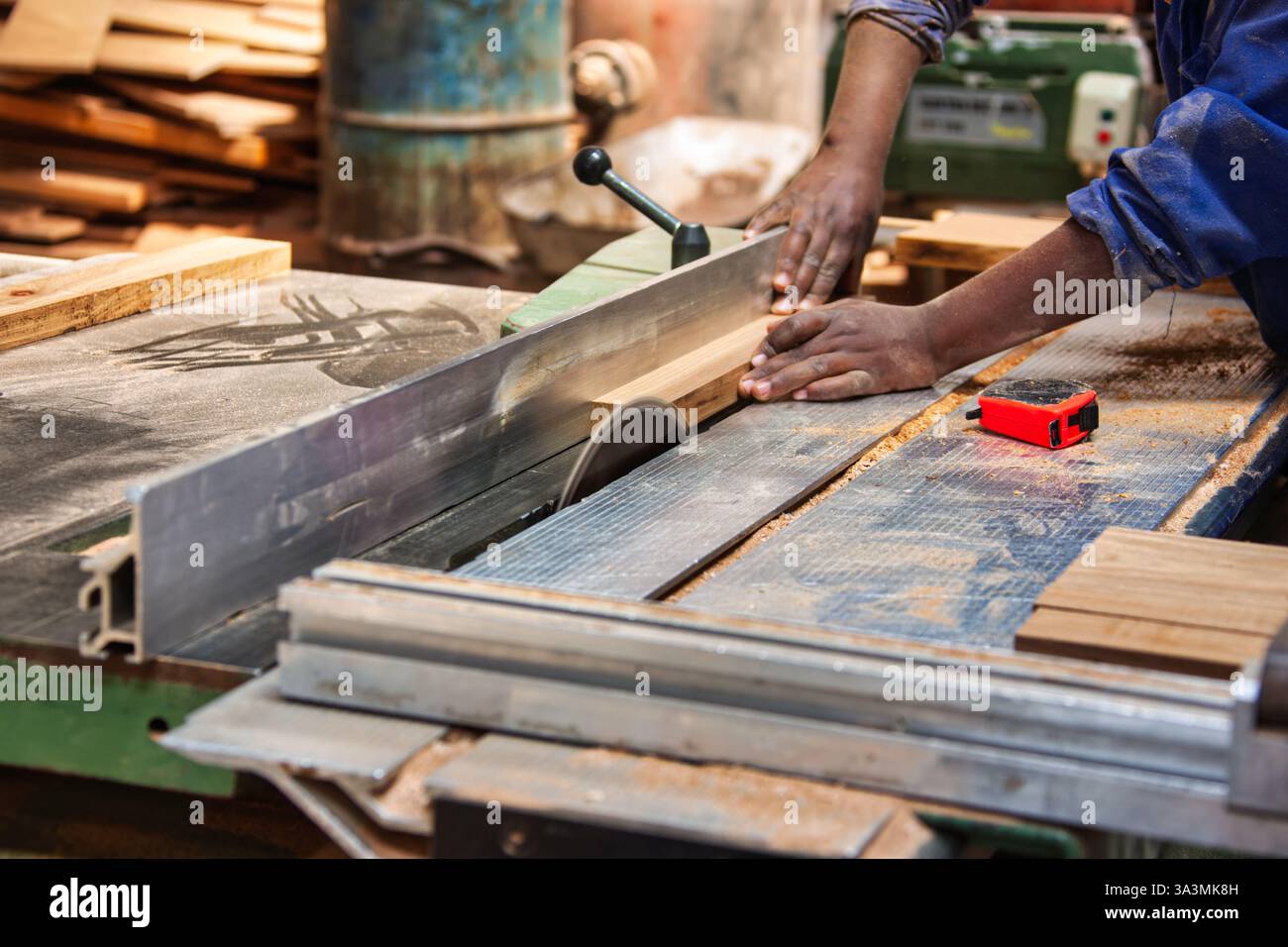 sega circolare taglio industriale fabbrica del legno operaio afroamericano Foto Stock