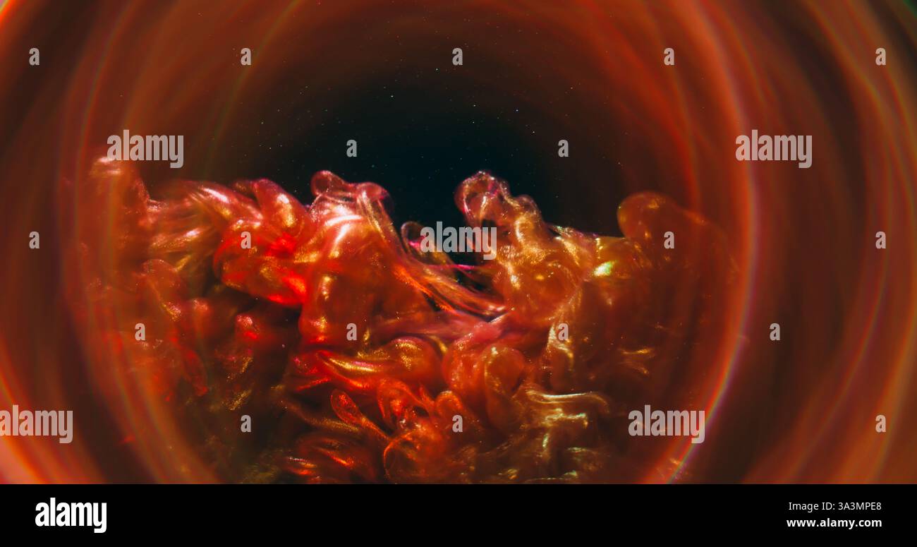 Esplosione di fumi. Inchiostro scintillante. Flusso di foschia ondulata lucida in metallo marrone arancione nell'acqua. Sfondo astratto con lenti rotonde sfocate dai colori brillanti. Foto Stock
