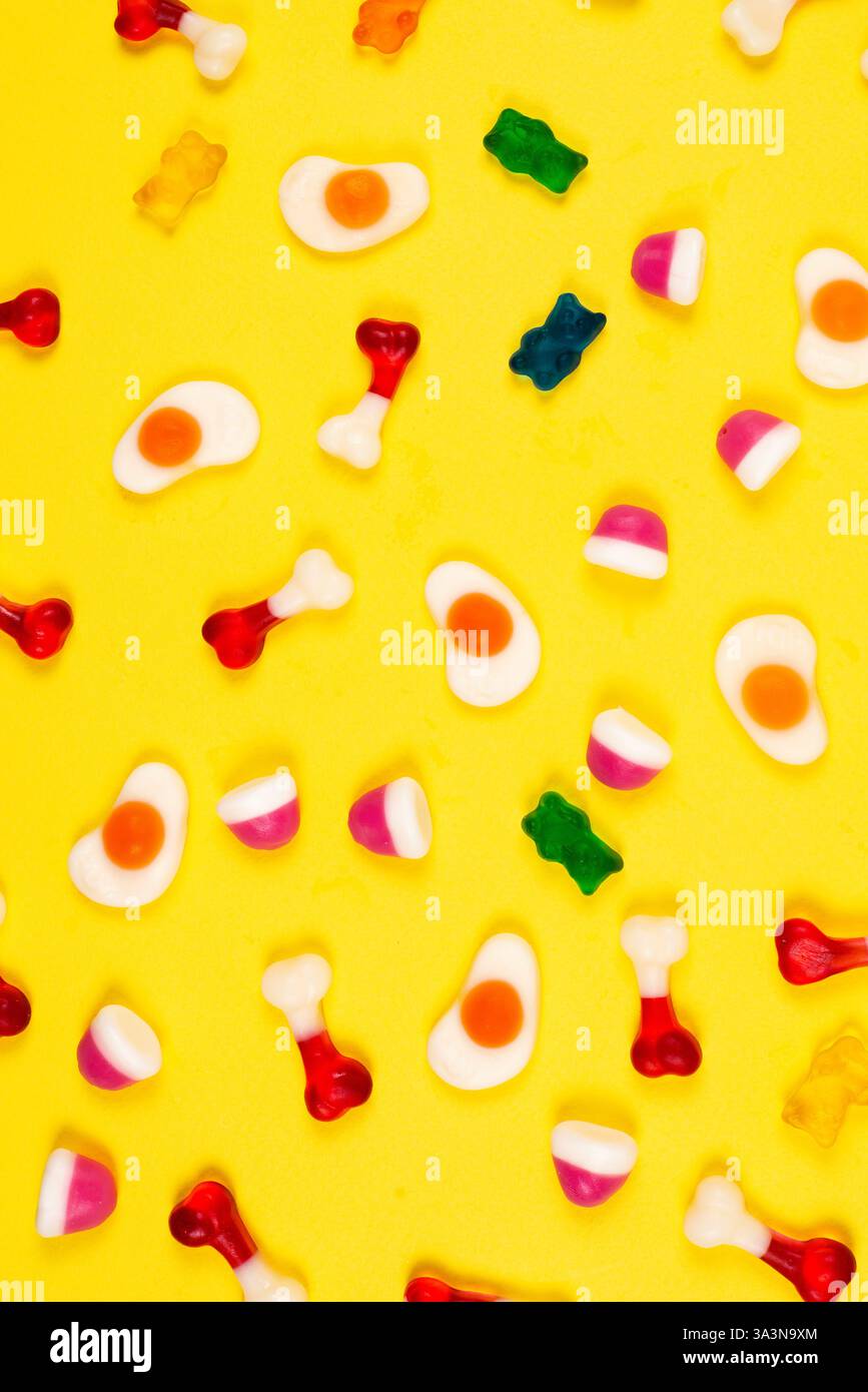 Dolci assortiti in gelatina su sfondo giallo. Ripetizione. Foto Stock