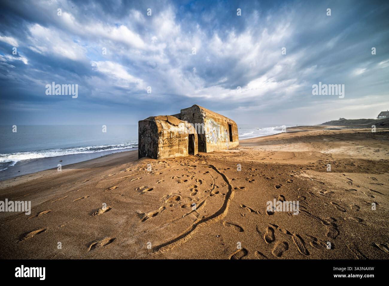 Tranquillo scenario costiero che mostra grandi bunker della seconda guerra mondiale con strutture intemprate sotto un cielo nuvoloso. Foto Stock