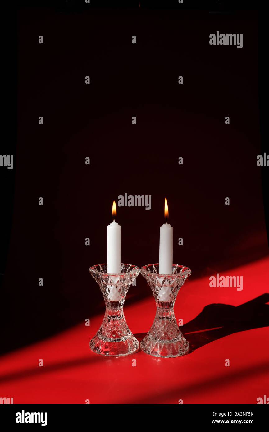 Coppia di candele bianche in portacandele in cristallo con vibrazione di San Valentino Foto Stock