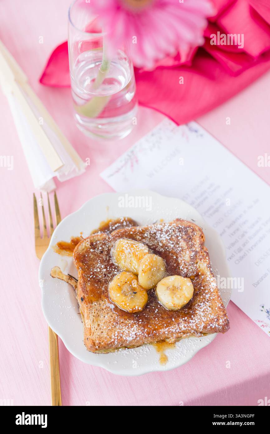 Toast alla francese con banane caramellate e zucchero a velo. Foto Stock
