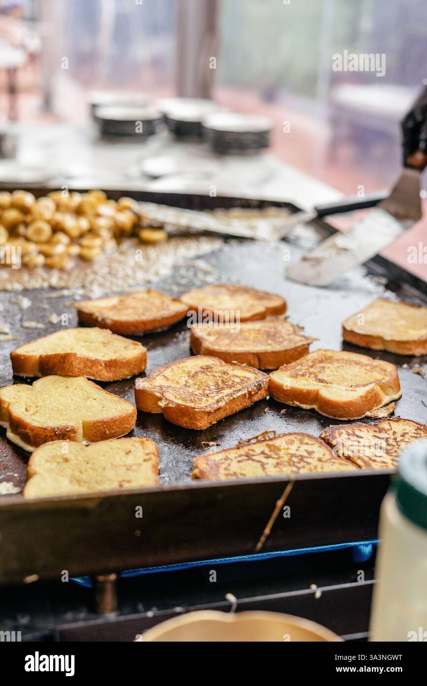 Toast alla francese dorato fette sfrigolanti su una piastra con banane. Foto Stock