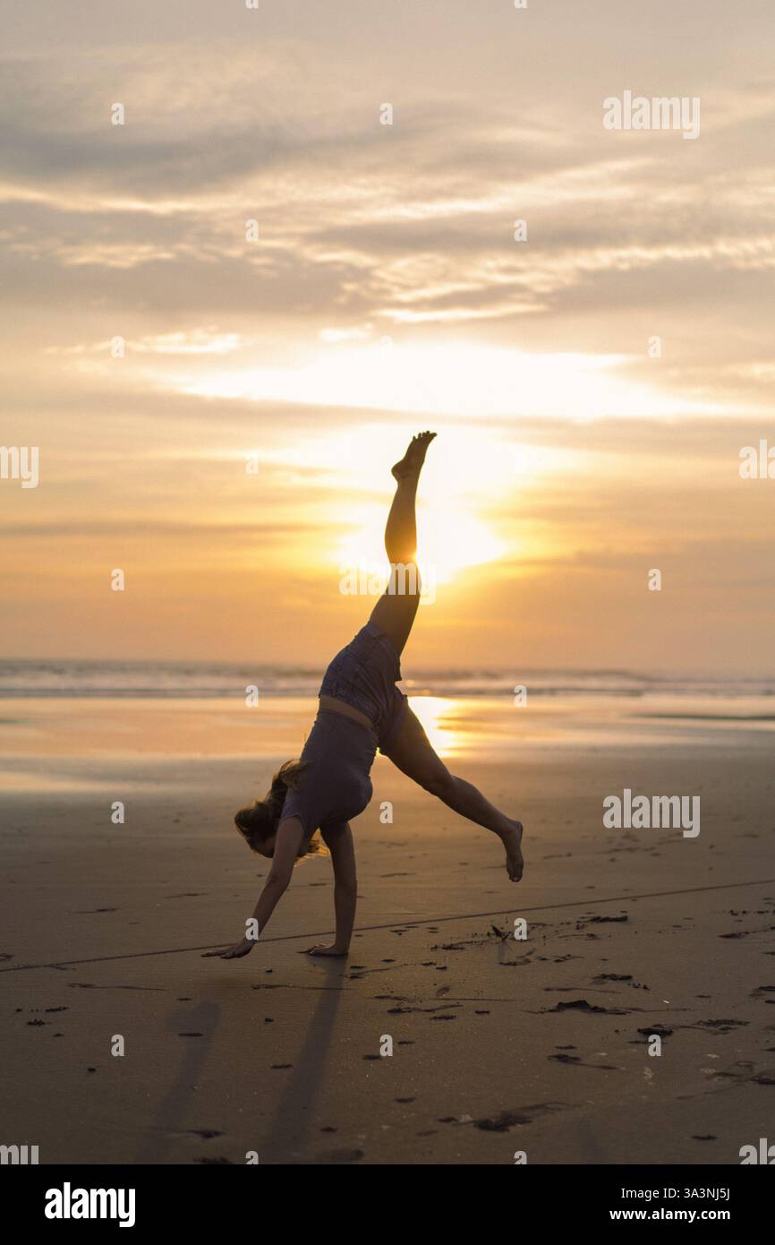 La donna fa il cartoncino sulla spiaggia Foto Stock