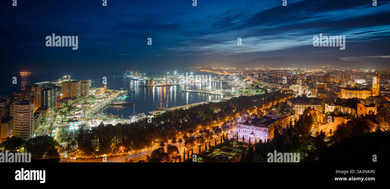 Città di Malaga di notte, vista panoramica del porticciolo, della cattedrale, del municipio e del centro città. Guardando in basso dal Castello di Gibralfaro di notte Foto Stock