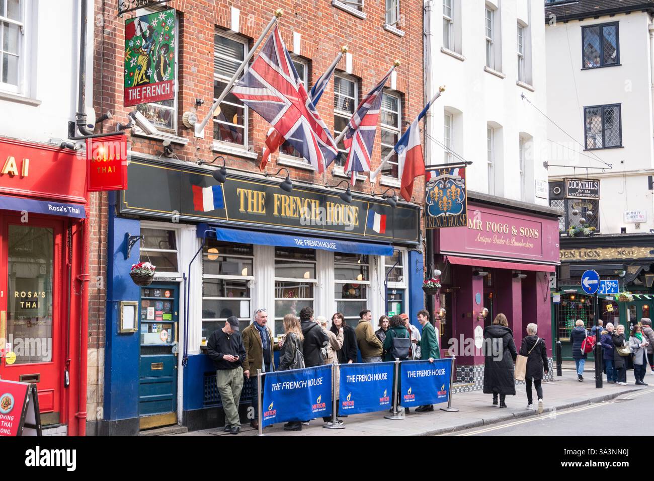 Tricolors e Union Jacks che volano all'esterno del pub French House in Dean Street, Soho, Londra, W1, Inghilterra, REGNO UNITO Foto Stock