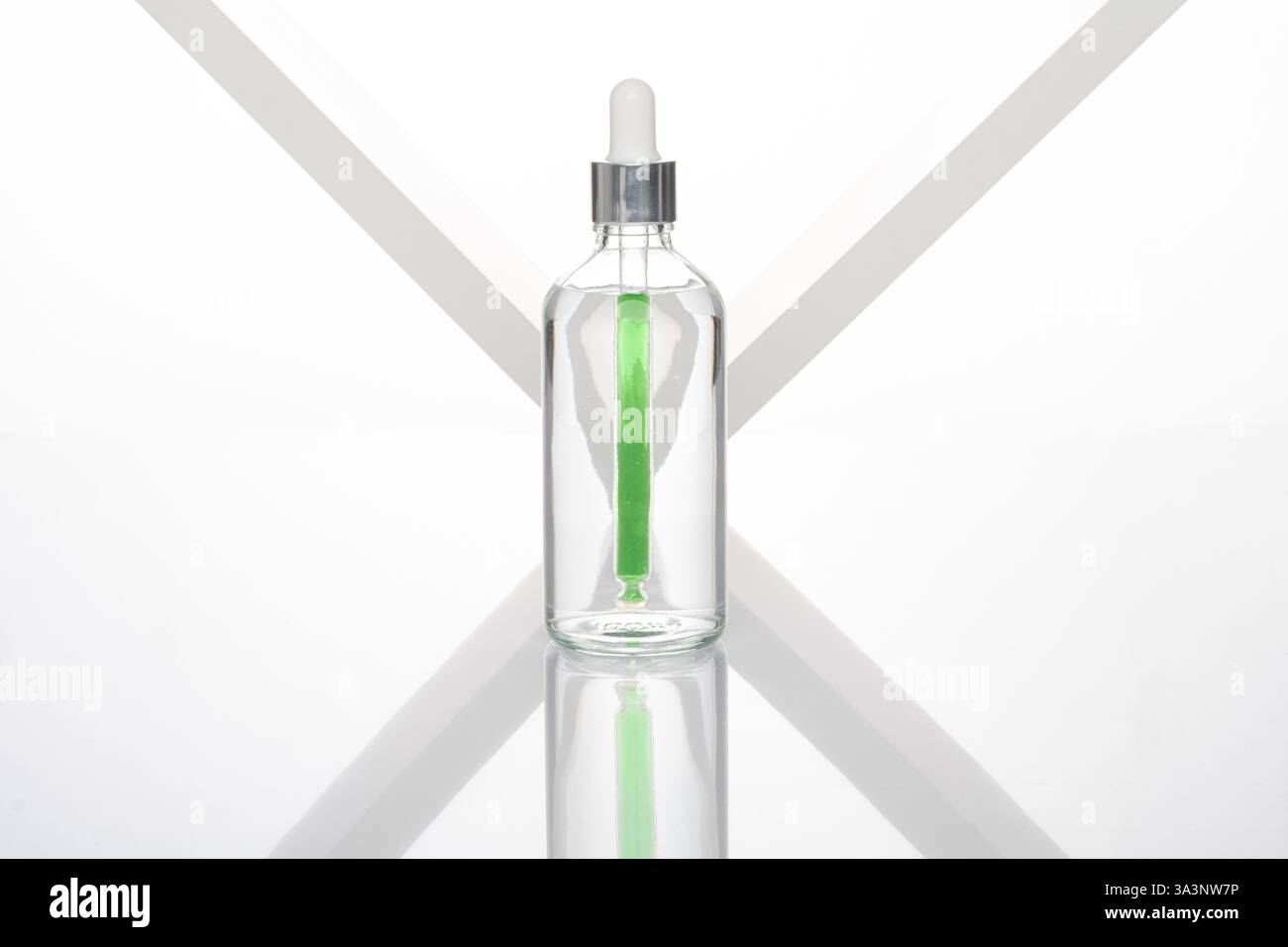 Flacone contagocce trasparente con fondo bianco e contagocce verde Foto Stock