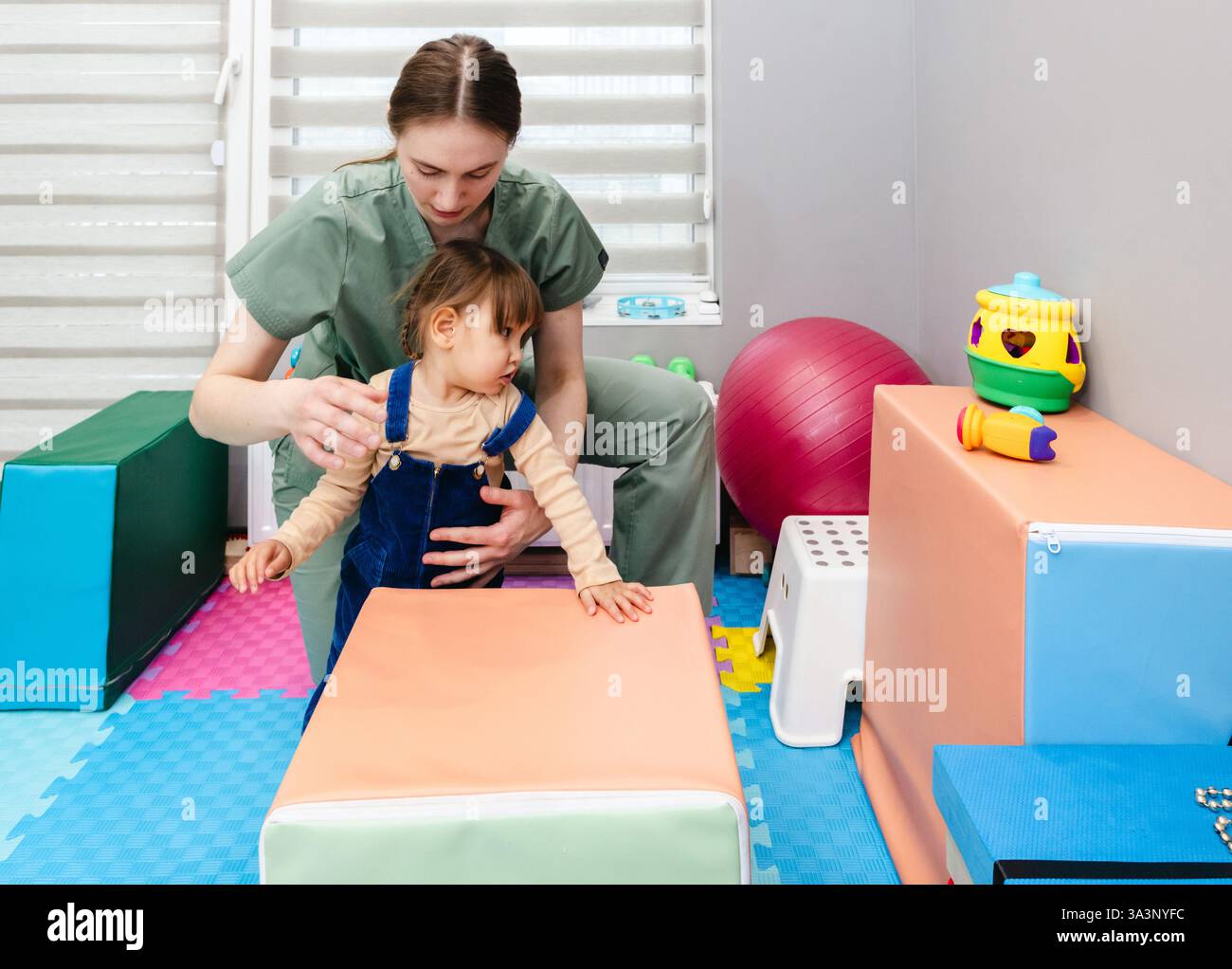 Fisioterapia infantile. Una piccola paziente riceve una terapia fisica da uno specialista Foto Stock