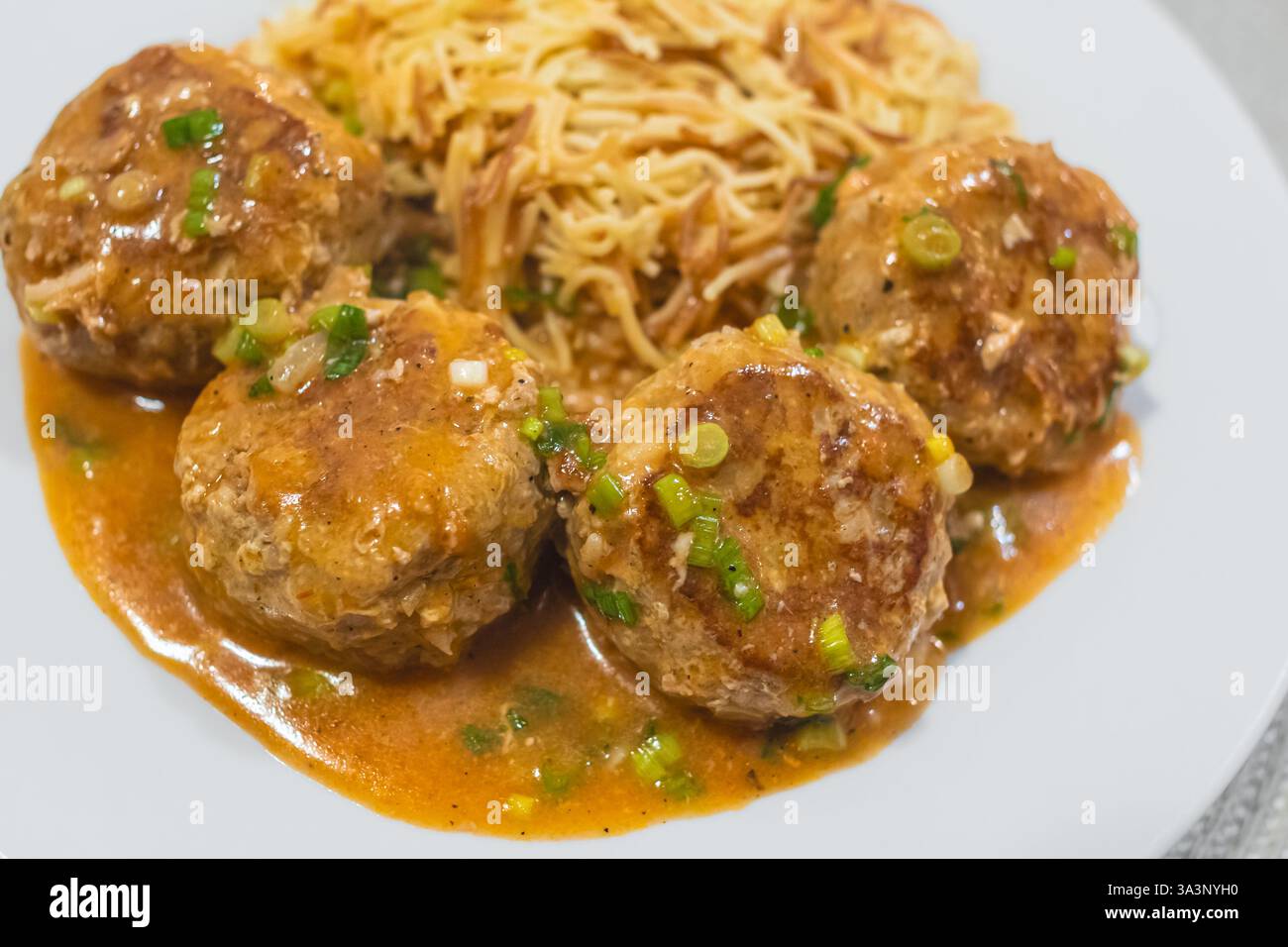 Gustose polpette con salsa e pasta. Polpette fatte in casa in salsa di pomodoro rosso su piatto bianco. Primo piano. Concetto di mangiare sano, nessuno Foto Stock