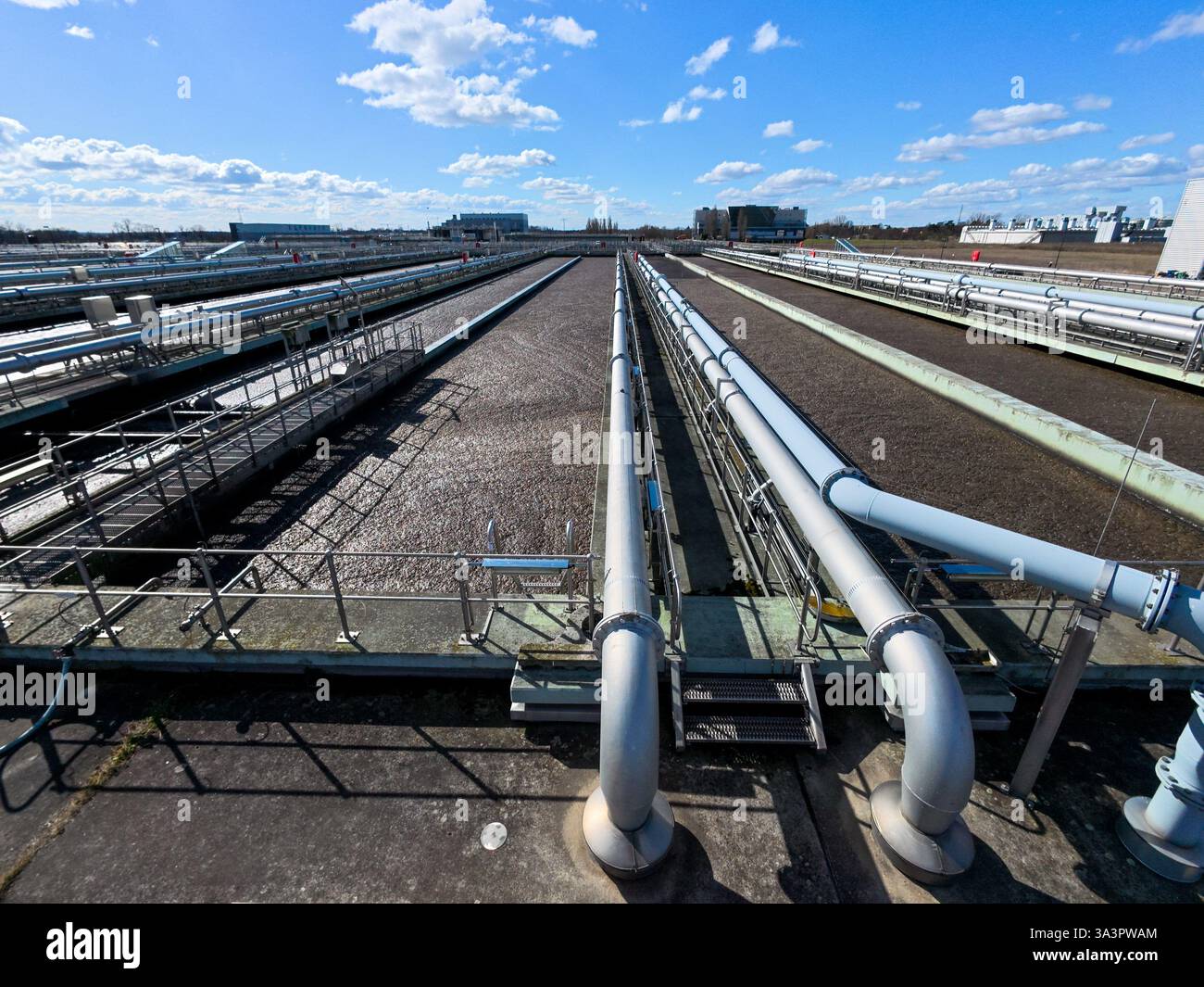 17 marzo 2025, Berlino, Schönefeld: L'acqua fluisce nei chiarificatori dell'impianto di depurazione di Waßmannsdorf. L'ampliamento dell'impianto di depurazione di Waßmannsdorf è stato completato. L'impianto di trattamento delle acque reflue comprende impianti per la rimozione dell'azoto e del fosforo ed è stato costruito anche un grande serbatoio di acqua mista. Foto: Carsten Koall/dpa Foto Stock