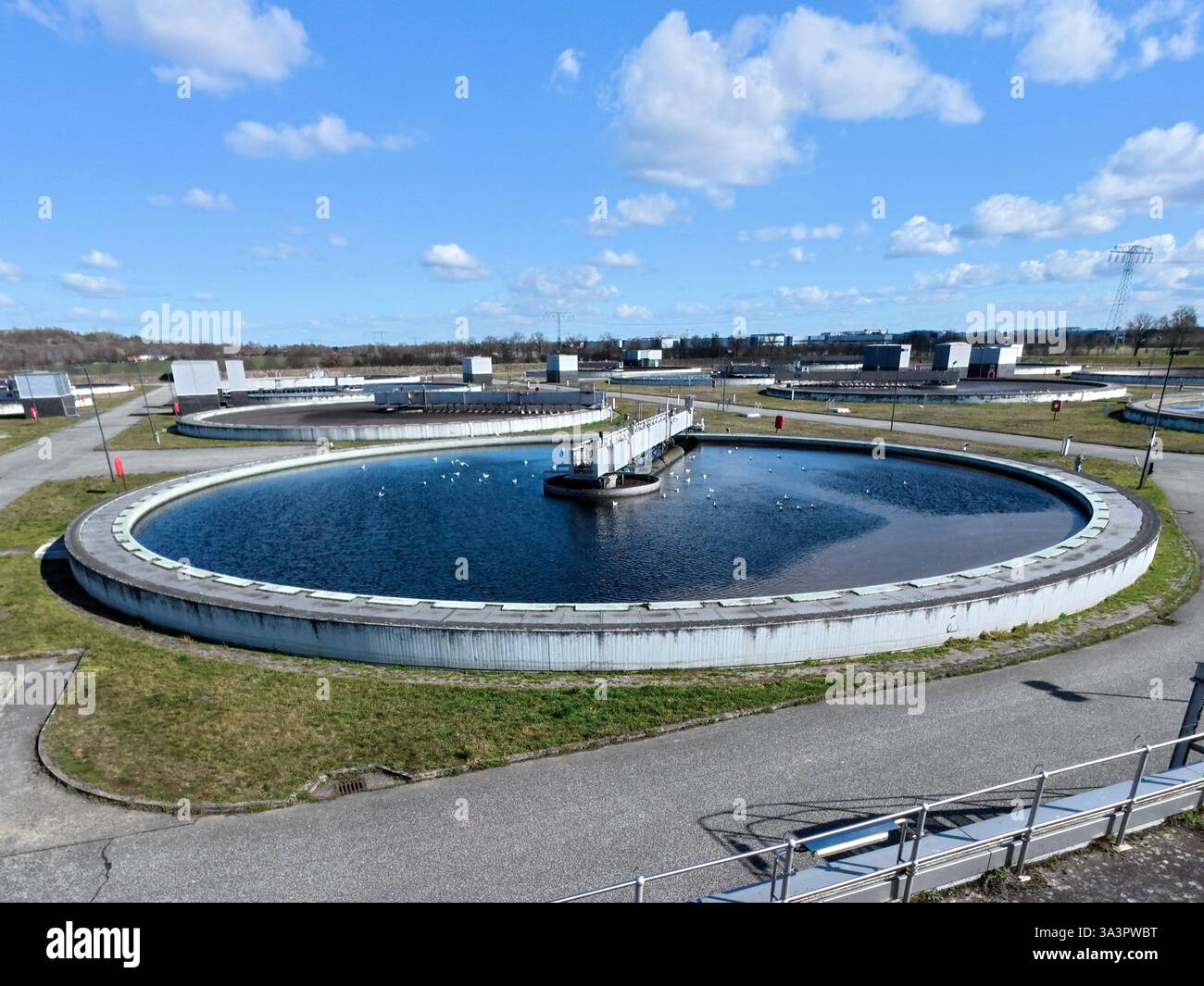 17 marzo 2025, Berlino, Schönefeld: L'acqua fluisce nei chiarificatori dell'impianto di depurazione di Waßmannsdorf. L'ampliamento dell'impianto di depurazione di Waßmannsdorf è stato completato. L'impianto di trattamento delle acque reflue comprende impianti per la rimozione dell'azoto e del fosforo ed è stato costruito anche un grande serbatoio di acqua mista. Foto: Carsten Koall/dpa Foto Stock