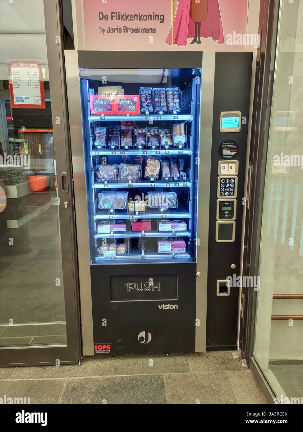 Distributore automatico di cioccolato della famosa pasticceria Broekmans nella stazione ferroviaria centrale di Eindhoven, nei Paesi Bassi, che vende anche alcuni biscotti - Immagine stock catturata con smartphone