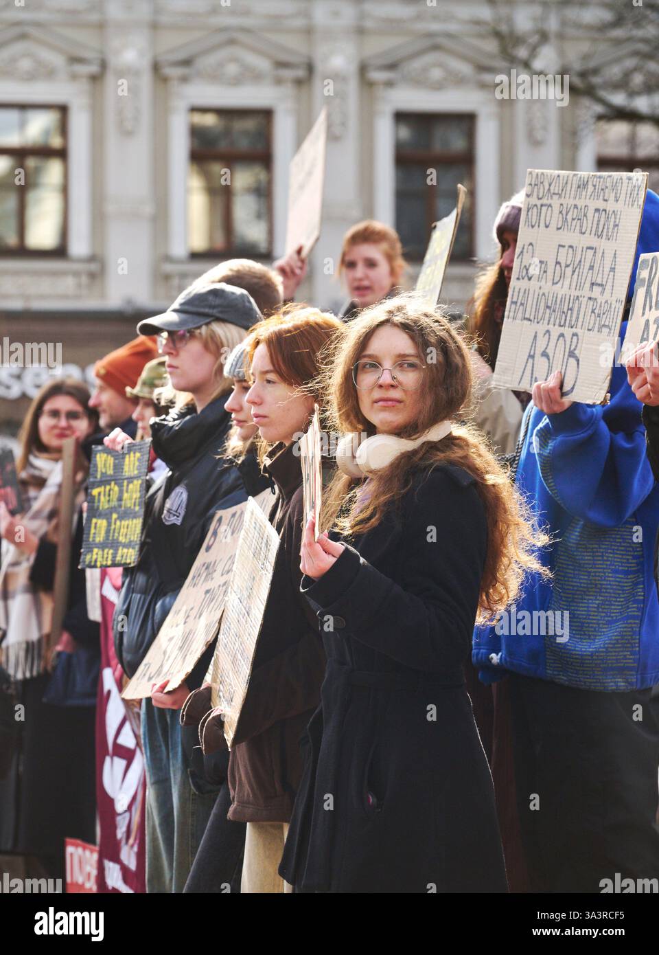 Kiev, Ucraina - 16 marzo 2025 persone con striscioni e cartelli in via Volodumirska presso l'Opera Nazionale Ucraina. Testo visibile sei loro Foto Stock