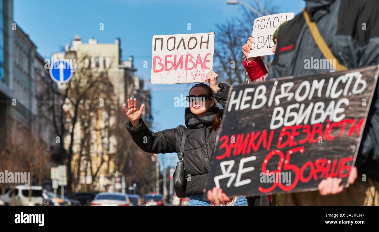 Kiev, Ucraina - 16 marzo 2025 persone che manifestano in via Volodumirska vicino all'Opera Nazionale Ucraina, tenendo striscioni con gli slogan Foto Stock