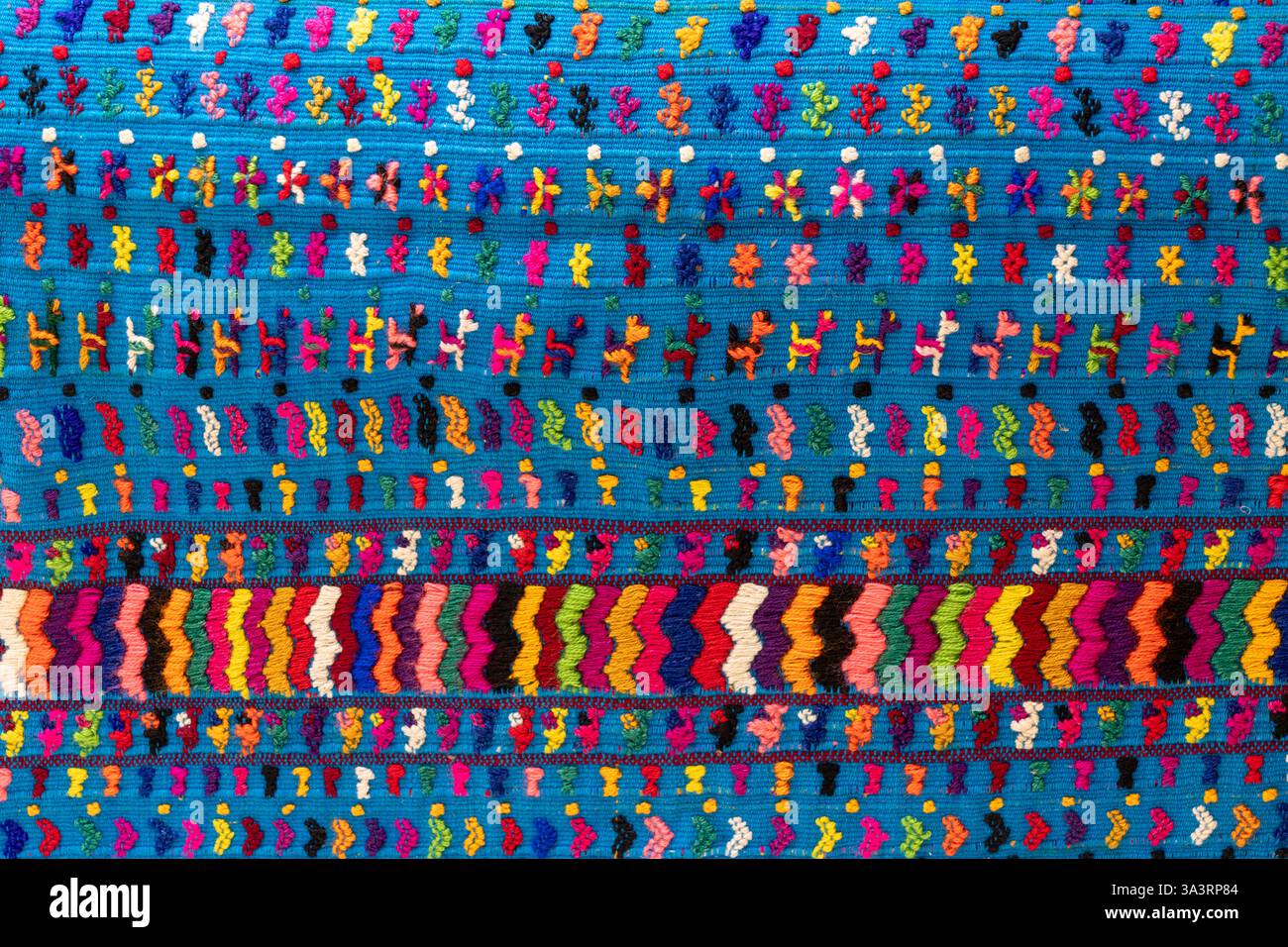 Un tessuto intrecciato con colorate figure ricamate del Guatemala. Tessuto su un telaio posteriore. Foto Stock