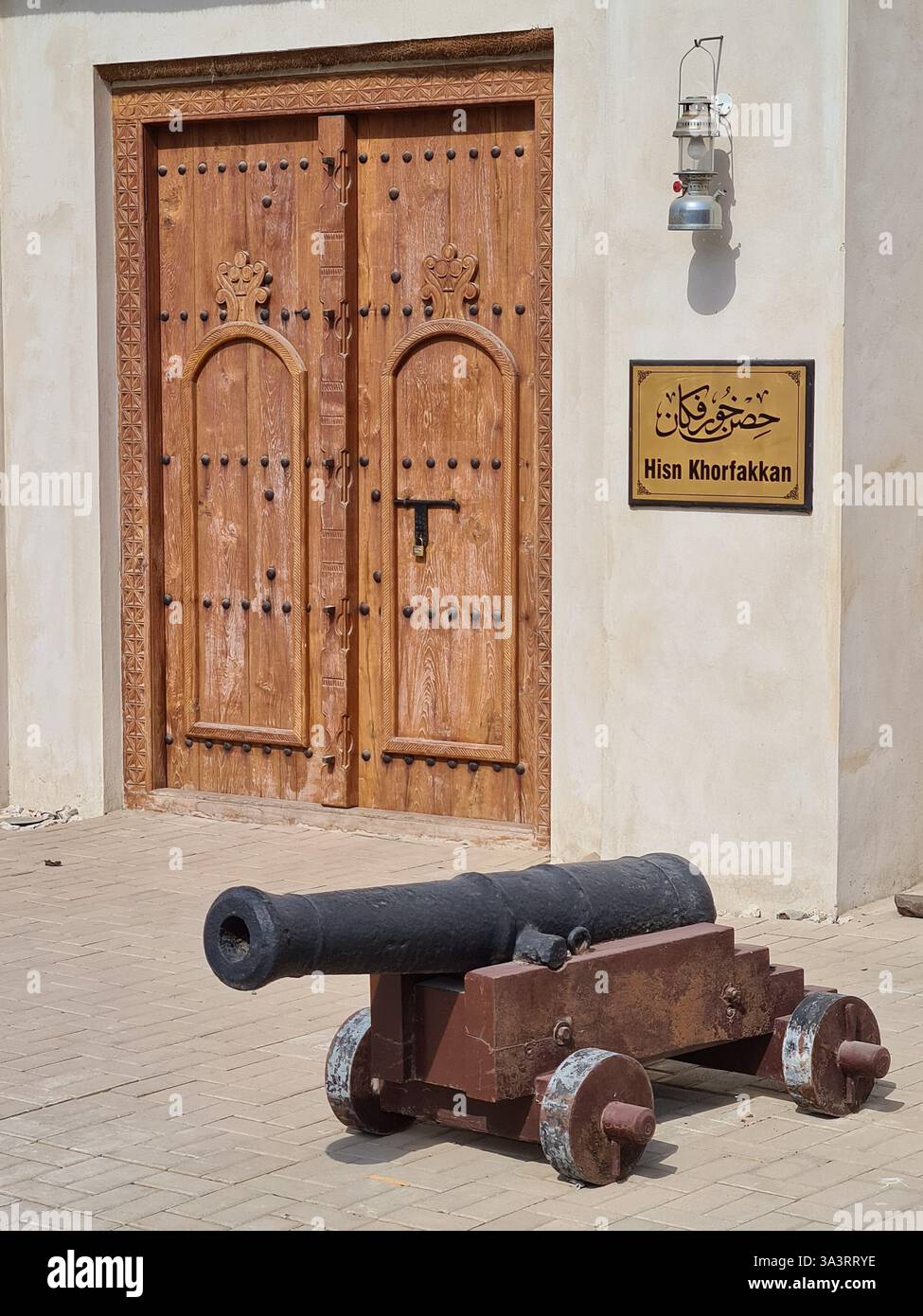 Storico cannone con porte in legno ornate, Hisn Khorfakkan Foto Stock