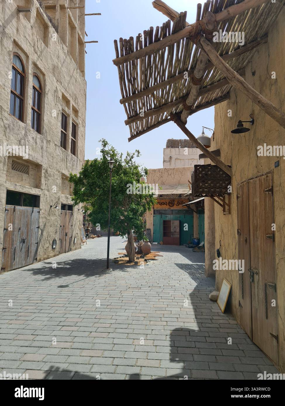 Vista ritratto del tradizionale vicolo mediorientale di al-Seef con strutture ombreggiate al sole pomeridiano a Dubai - Immagine stock catturata con smartphone