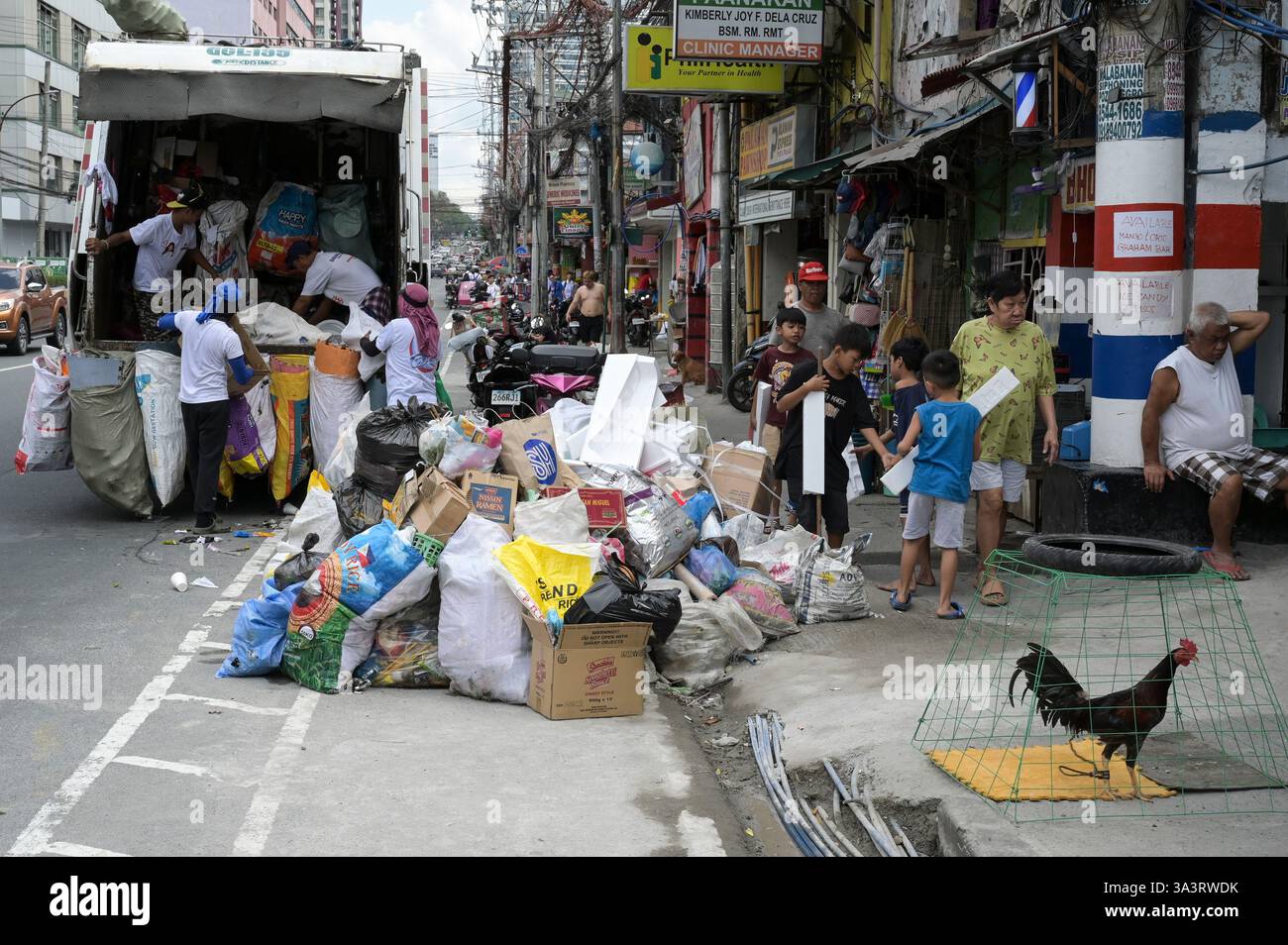FILIPPINE, Manila, Quezon City, il camion dei rifiuti raccoglie la spazzatura dalla strada / PHILIPPINEN, Müllwagen holt Müll ab, der Müll wird sofort nach verwertbaren Materialien sortiert, Die an junk Shops in Payatas zum weiteren Recycling verkauft werden Foto Stock