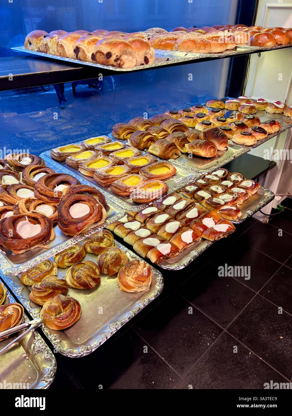 Pasticceria danese con scaffali pieni di pasticcini appena cucinati al mattino. Foto Stock