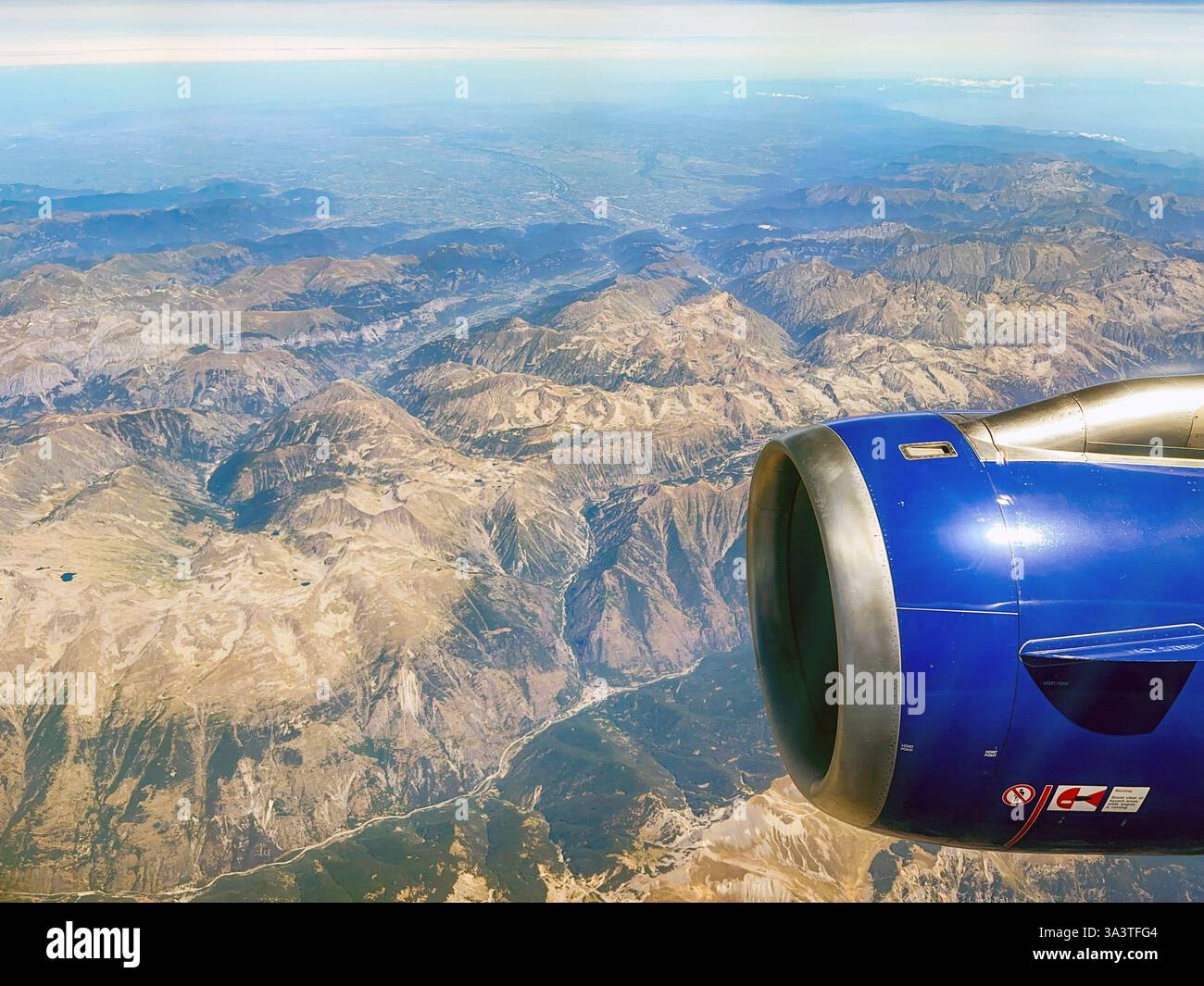 In rotta da Malta a Londra - 9 agosto 2023: Vista panoramica delle Alpi svizzere e un motore a reazione da un posto vicino al finestrino in un jet da vacanza. - Immagine stock catturata con smartphone