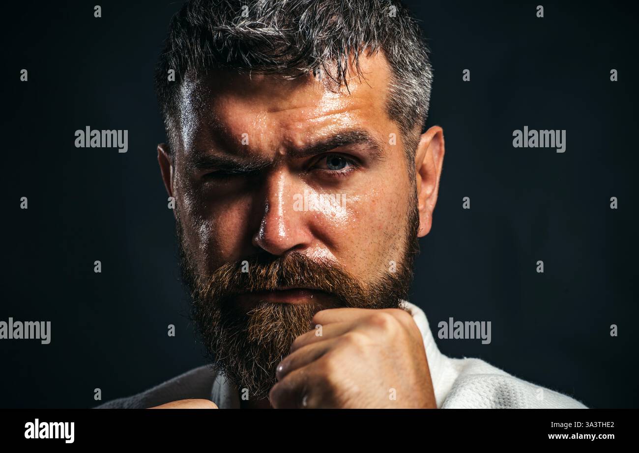 L'uomo di karate si sta preparando per la competizione. Combattente muscoloso pronto per l'allenamento di karate. Ritratto ravvicinato di un atleta barbuto che pratica l'aikido o il taek Foto Stock