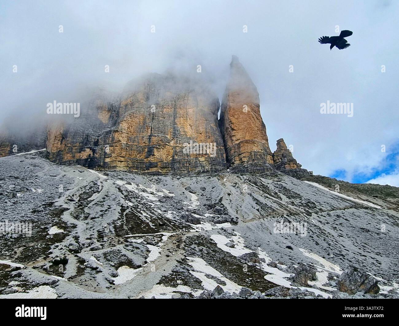 Vista dal famoso percorso circolare di un uccello volante e le famose vette delle tre Cime di Lavaredo tra le nuvole Foto Stock
