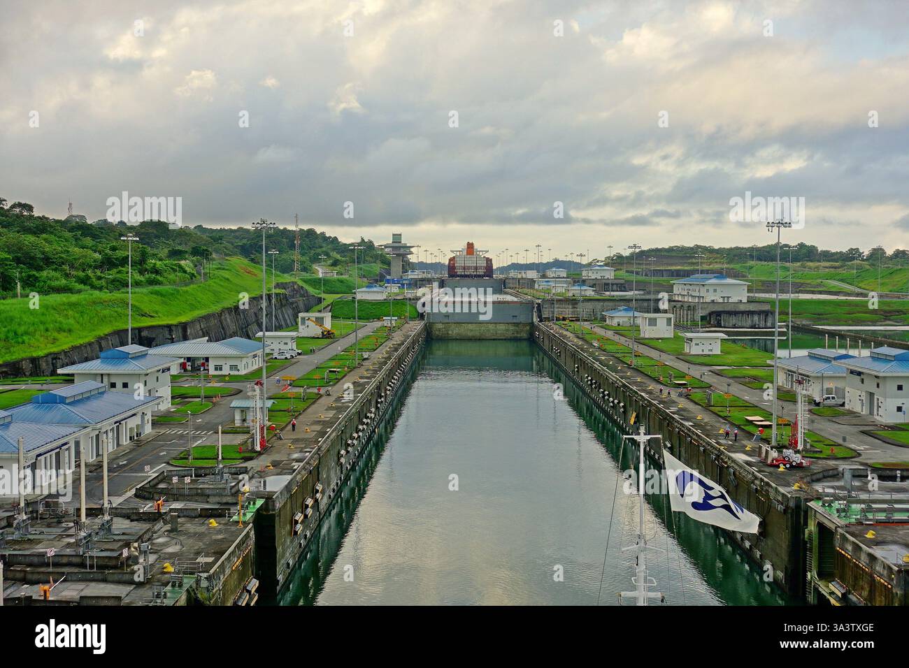 Paesaggio panoramico con il canale artificiale di Panama, edifici tecnici e spazi verdi la mattina presto all'alba Foto Stock